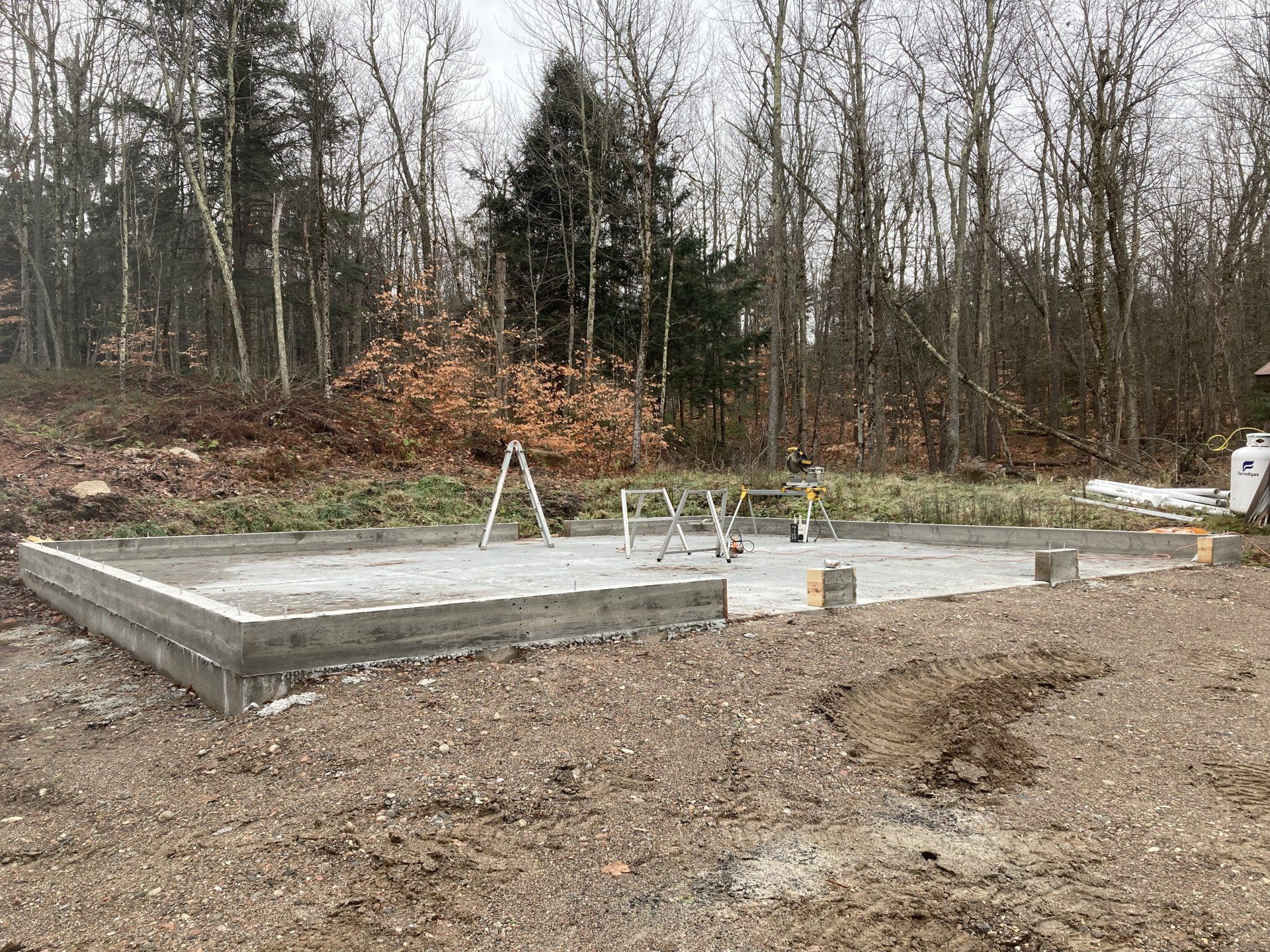 A concrete foundation is being built in the middle of a dirt field.