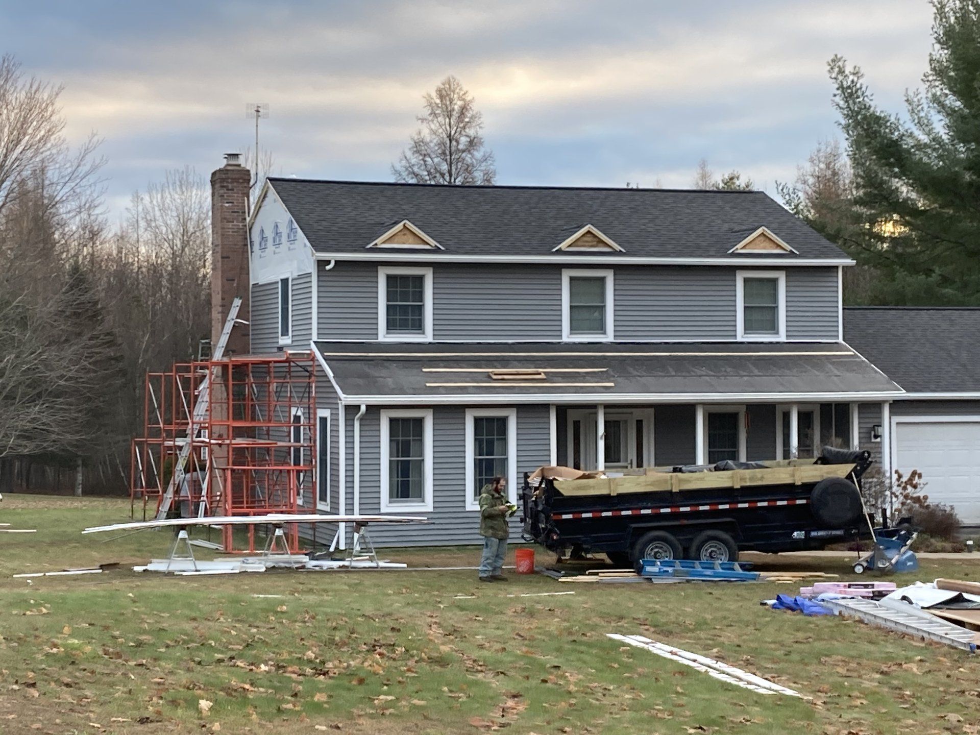 A house that is being remodeled with a dumpster in front of it