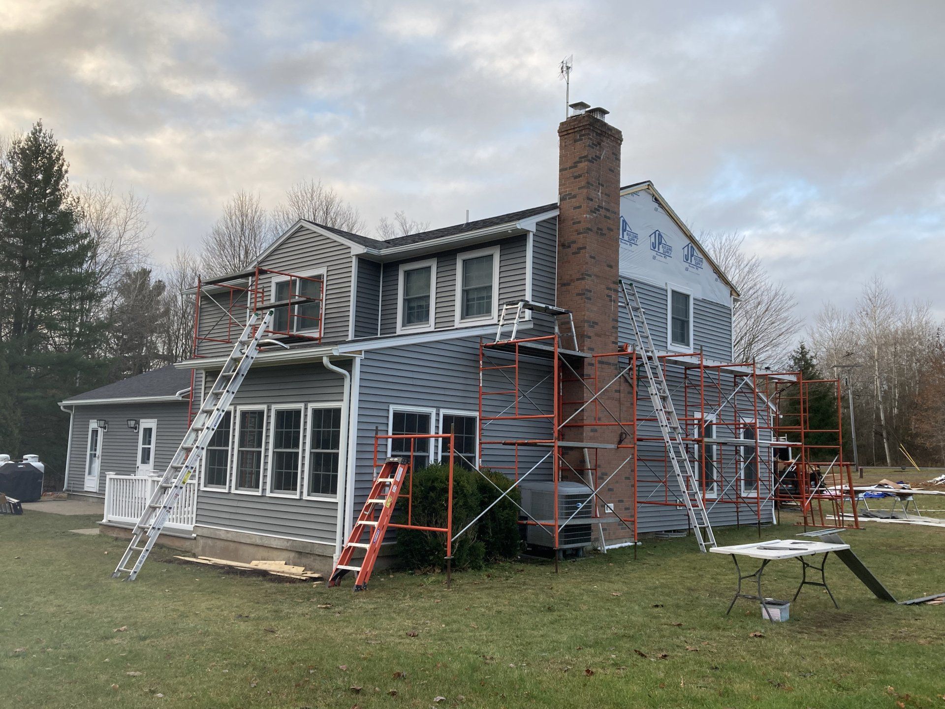 A large house with scaffolding around it is being painted.