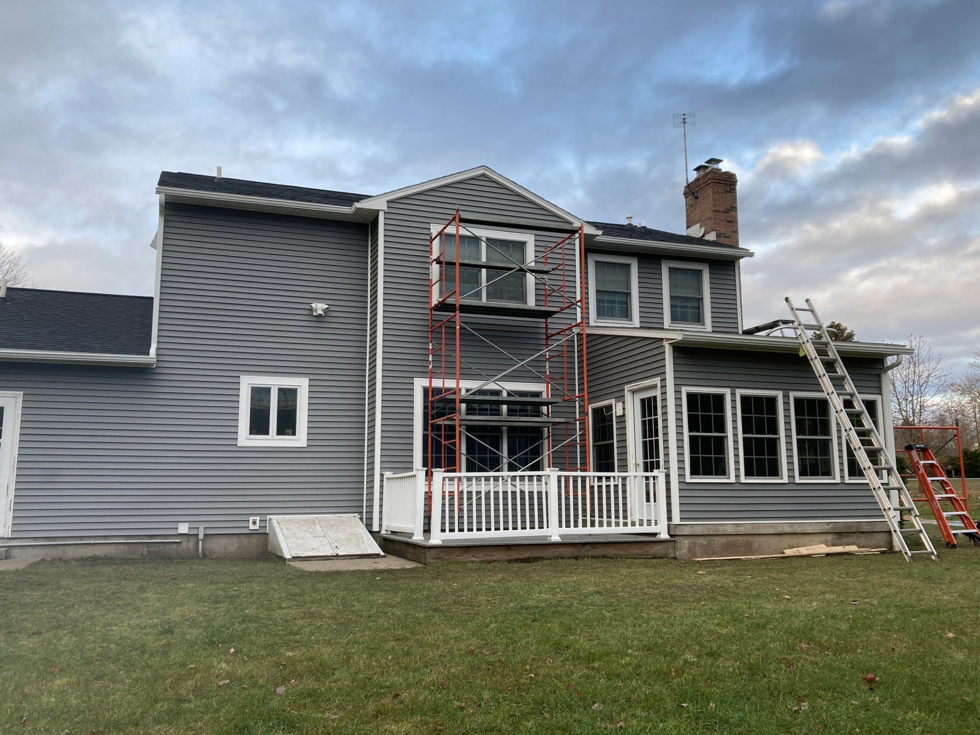 A large house with a scaffolding in front of it is being painted.