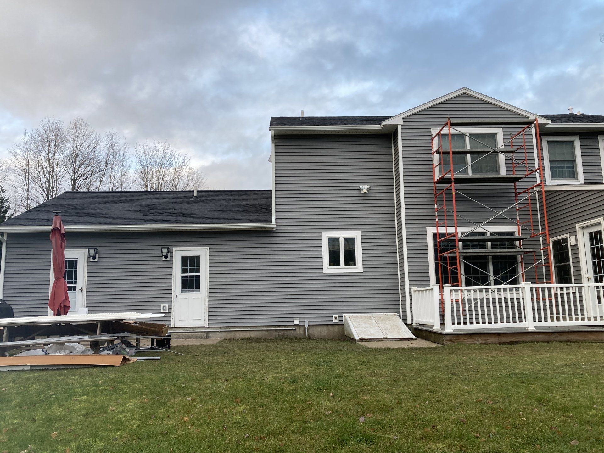 A large house with a scaffolding in front of it is being painted.