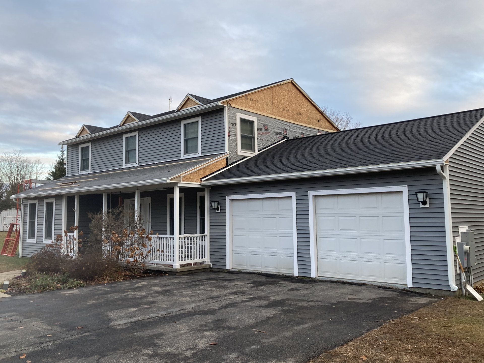 A large house with two garage doors and a porch.