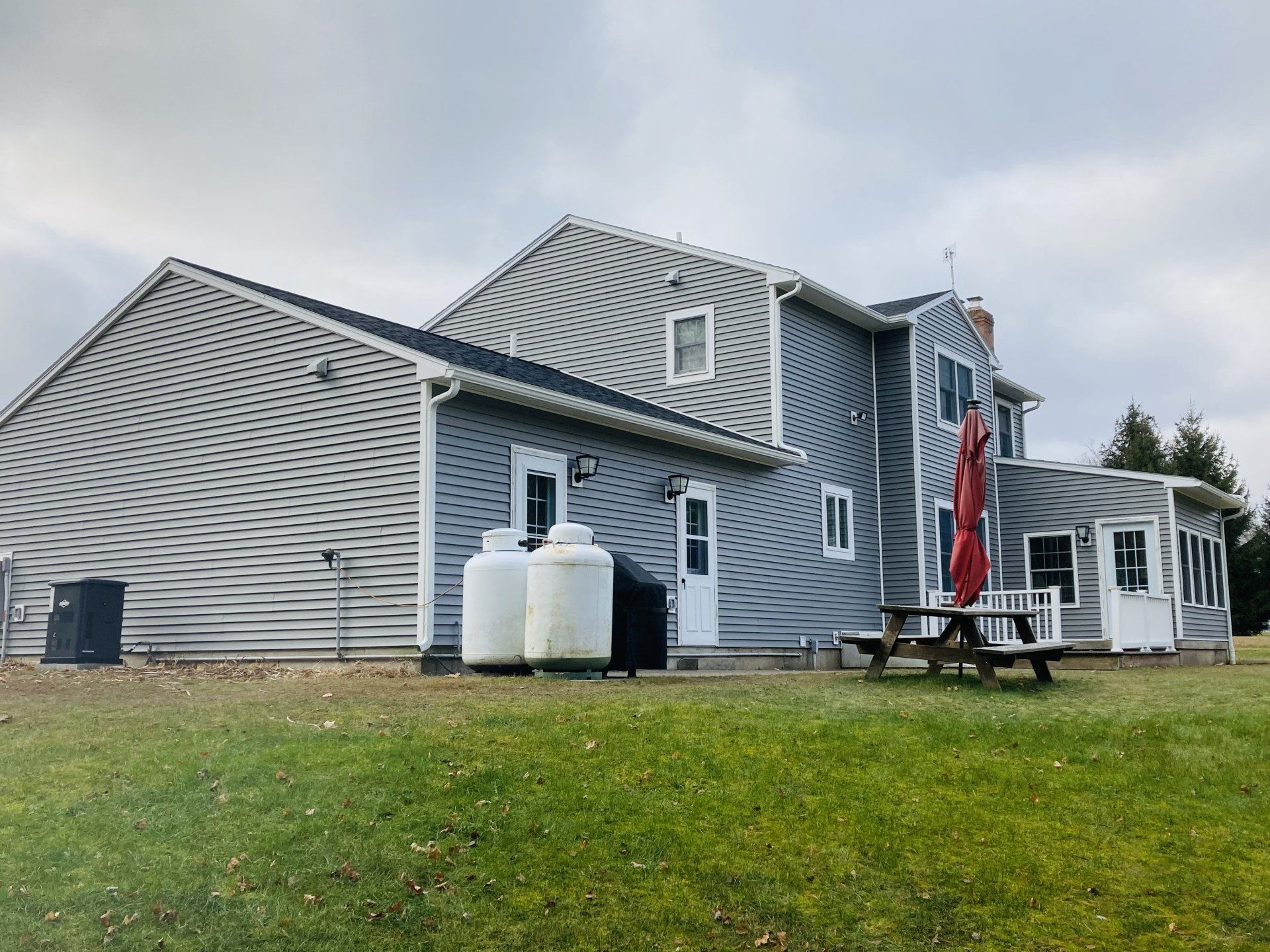 A large house with a picnic table in front of it.