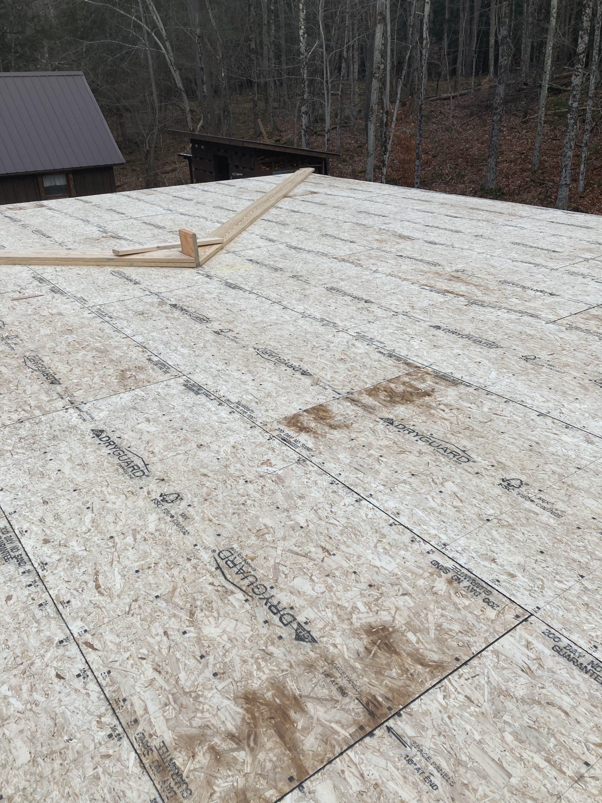 A roof with a lot of plywood on it is being built.
