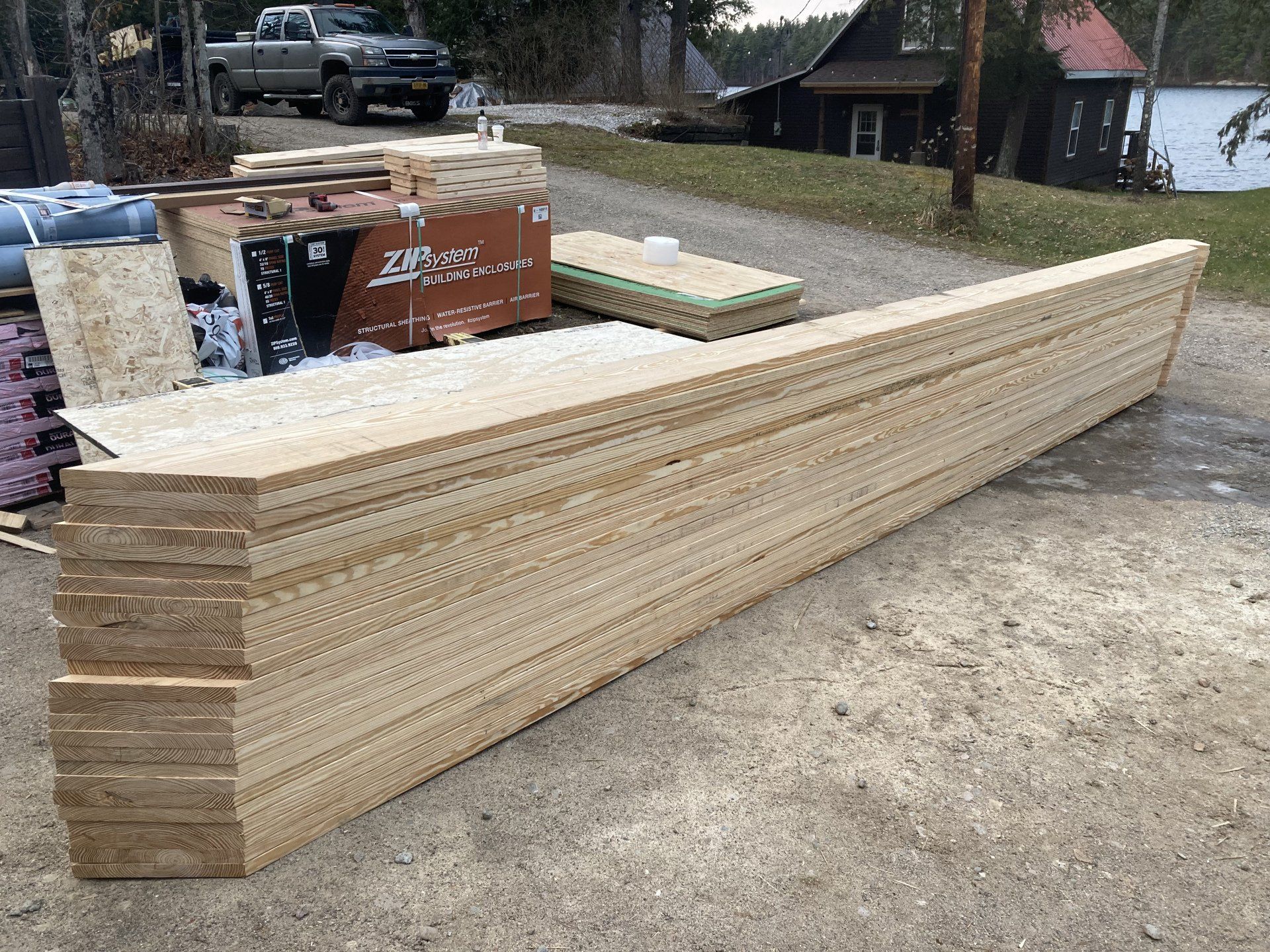 A stack of wood sitting on top of a dirt road.