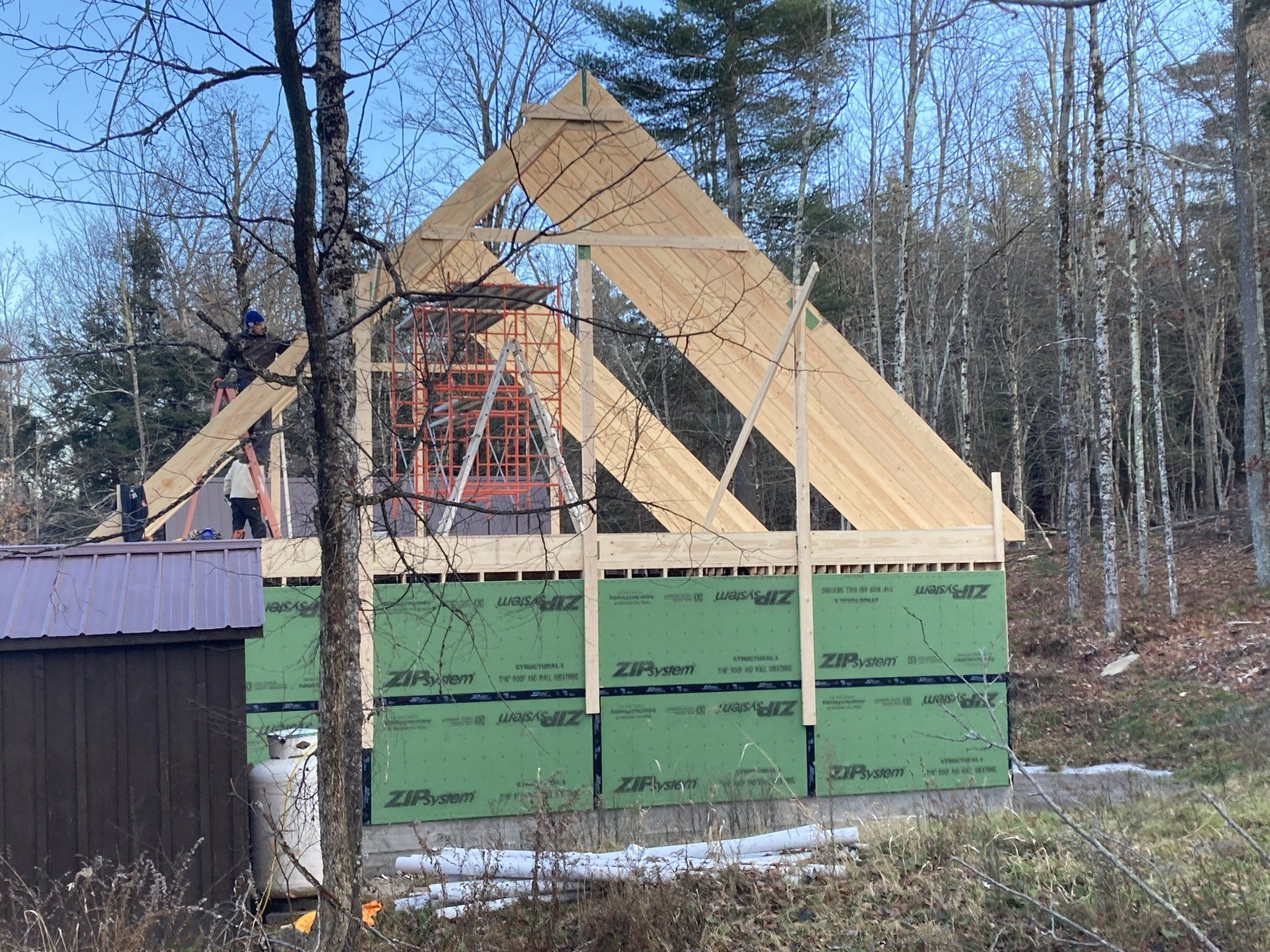 A wooden structure is being built in the middle of a forest.