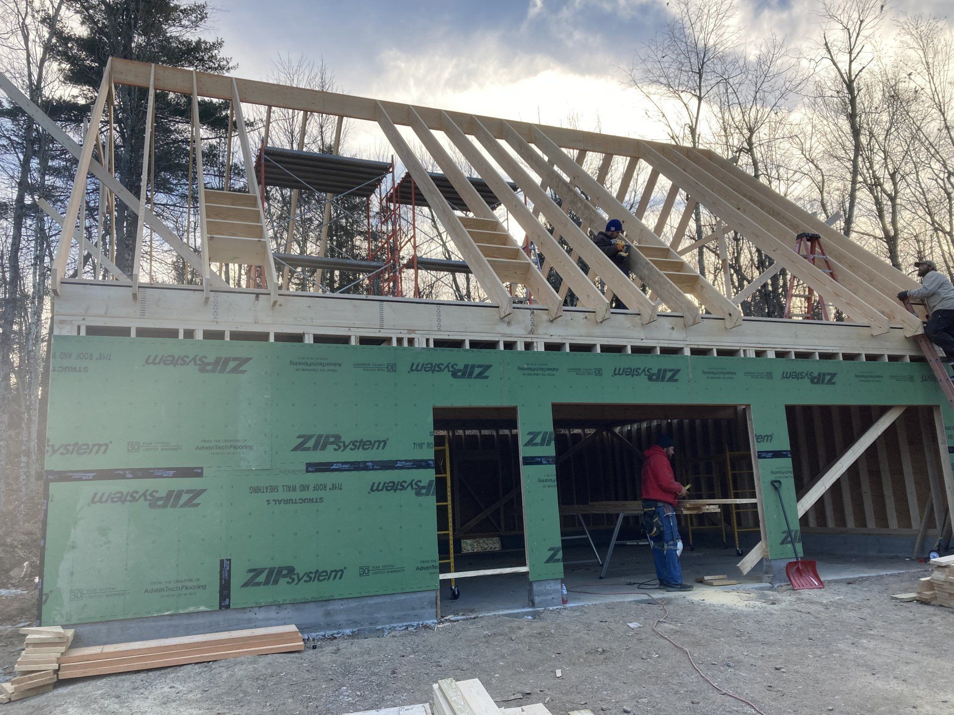 A building under construction with a green wall that says zip-wall