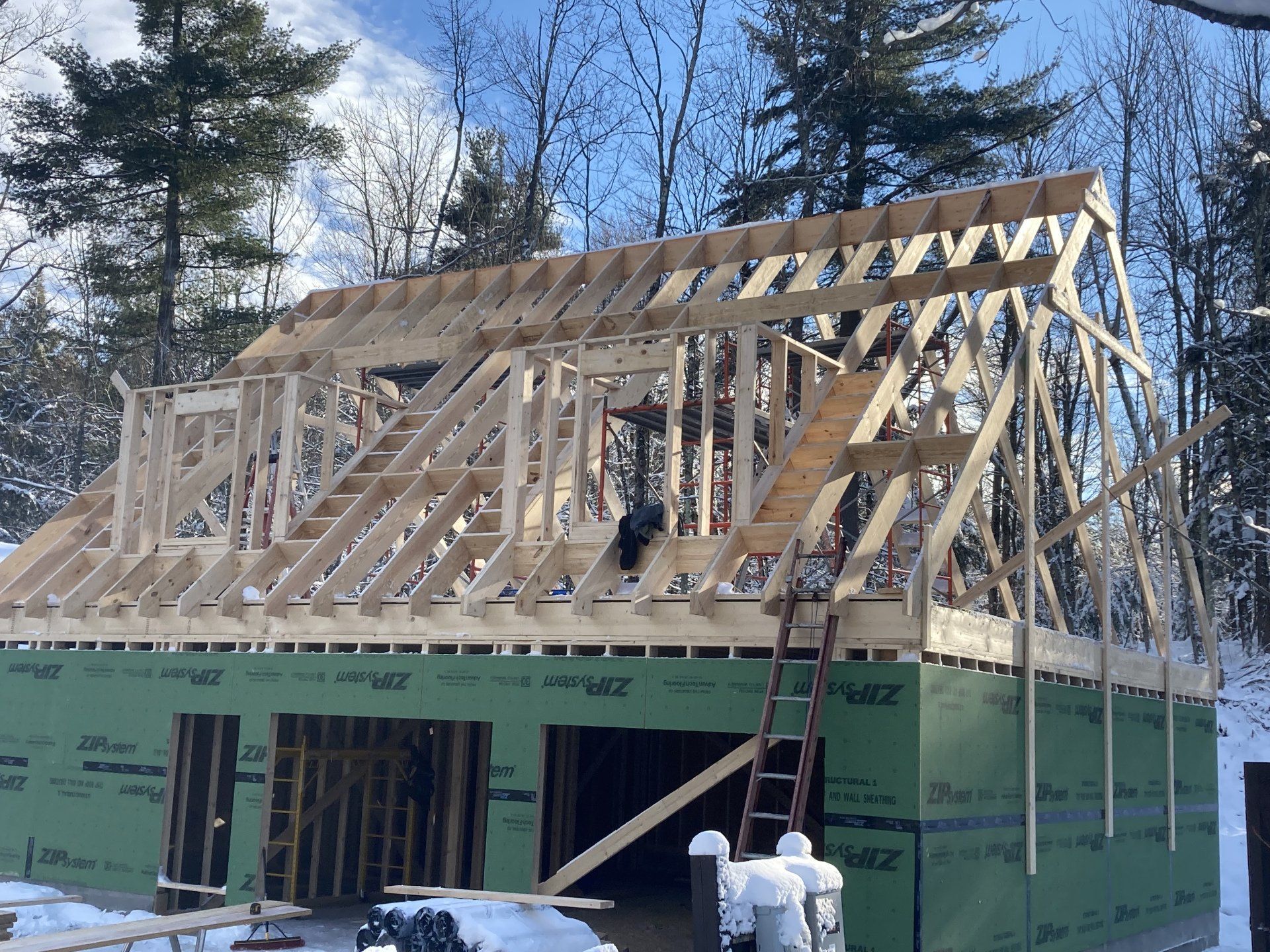 The roof of a house is being built in the snow.