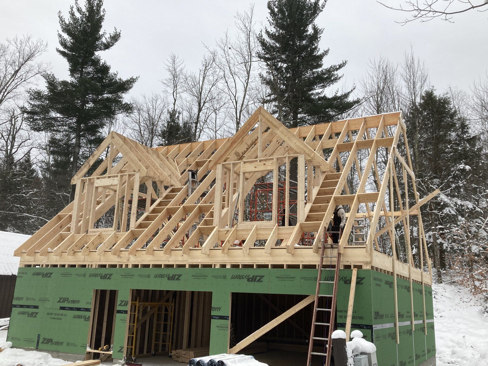 A wooden house is being built in the snow.