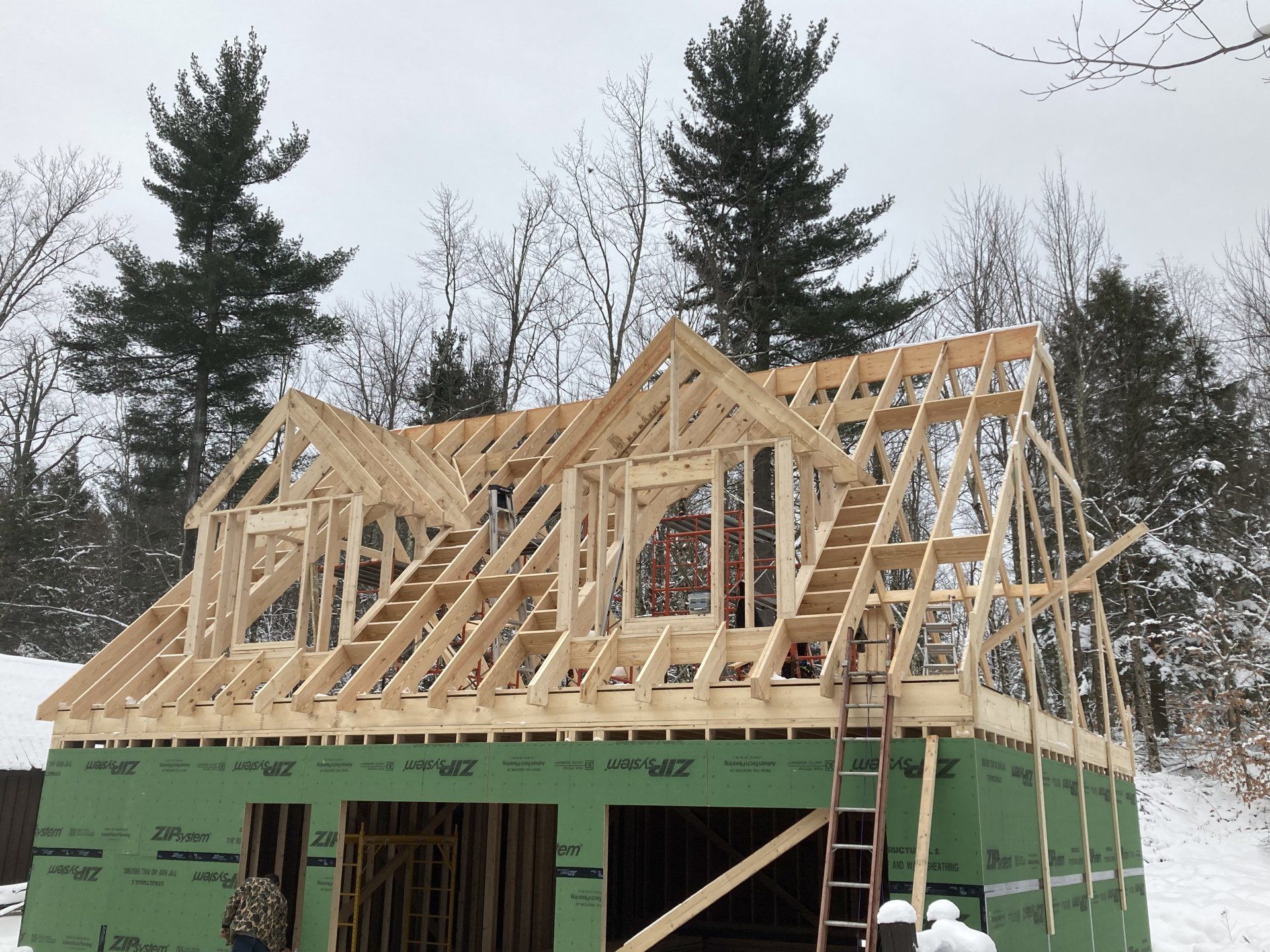 The roof of a house is being built in the snow