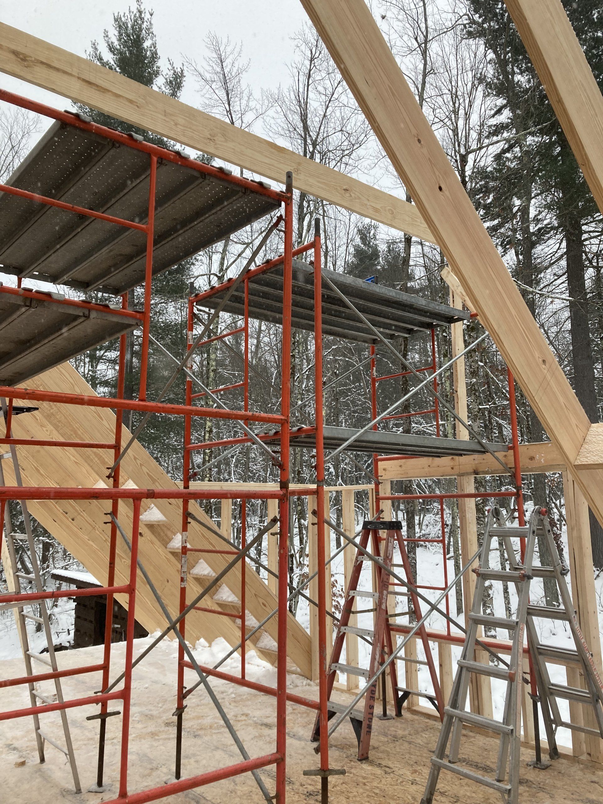 A building under construction with scaffolding and ladders