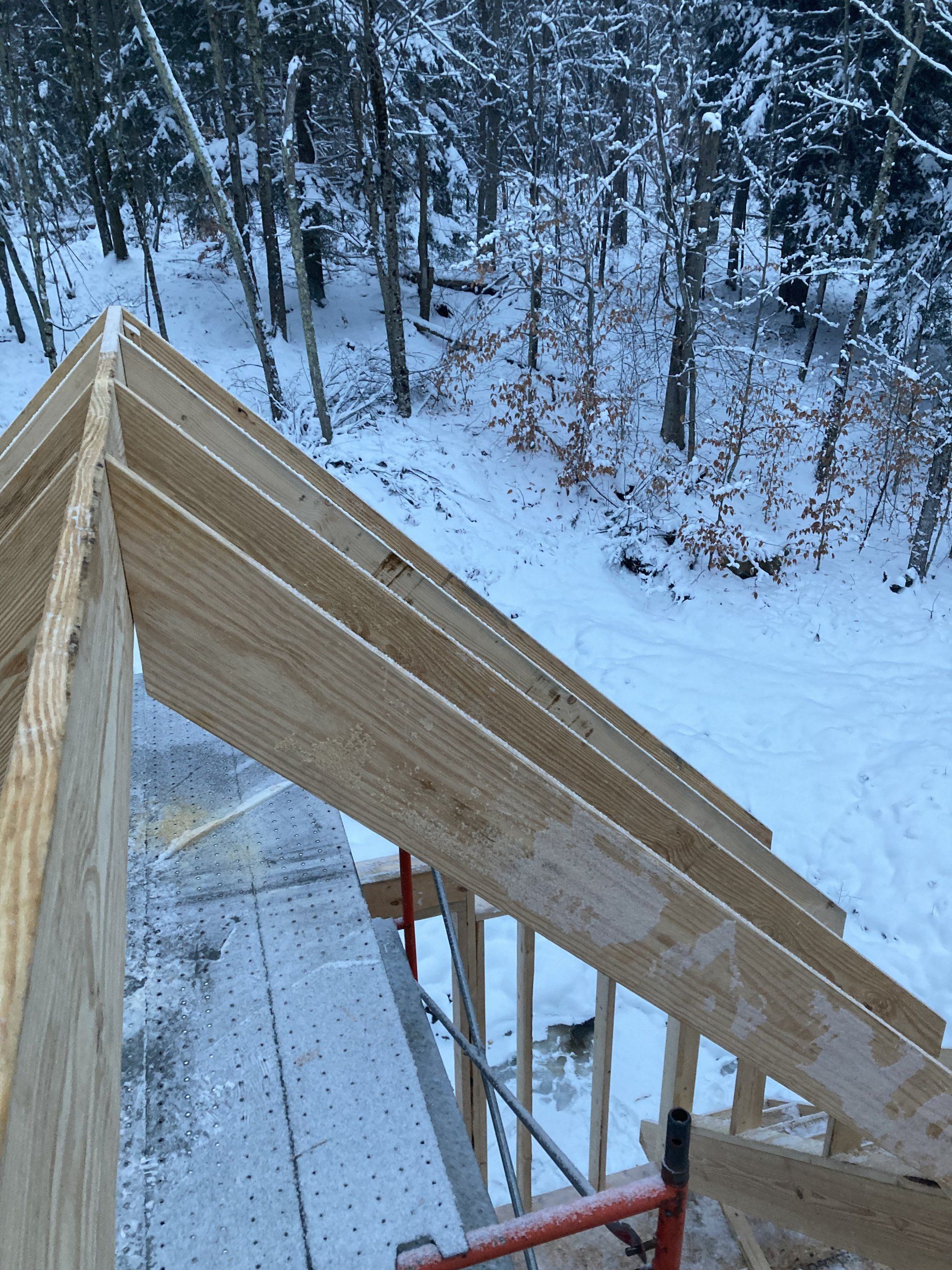 A wooden structure is being built in the snow.