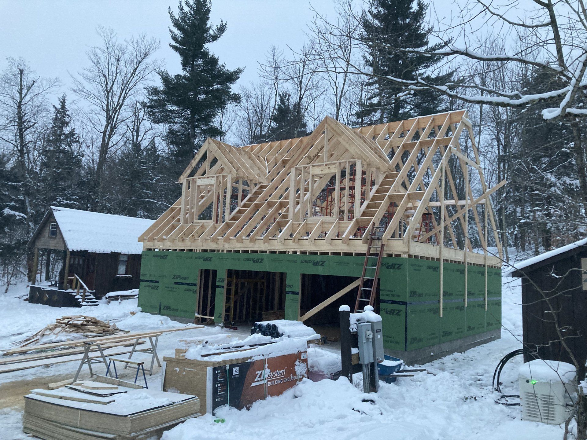 A house is being built in the snow in the woods.