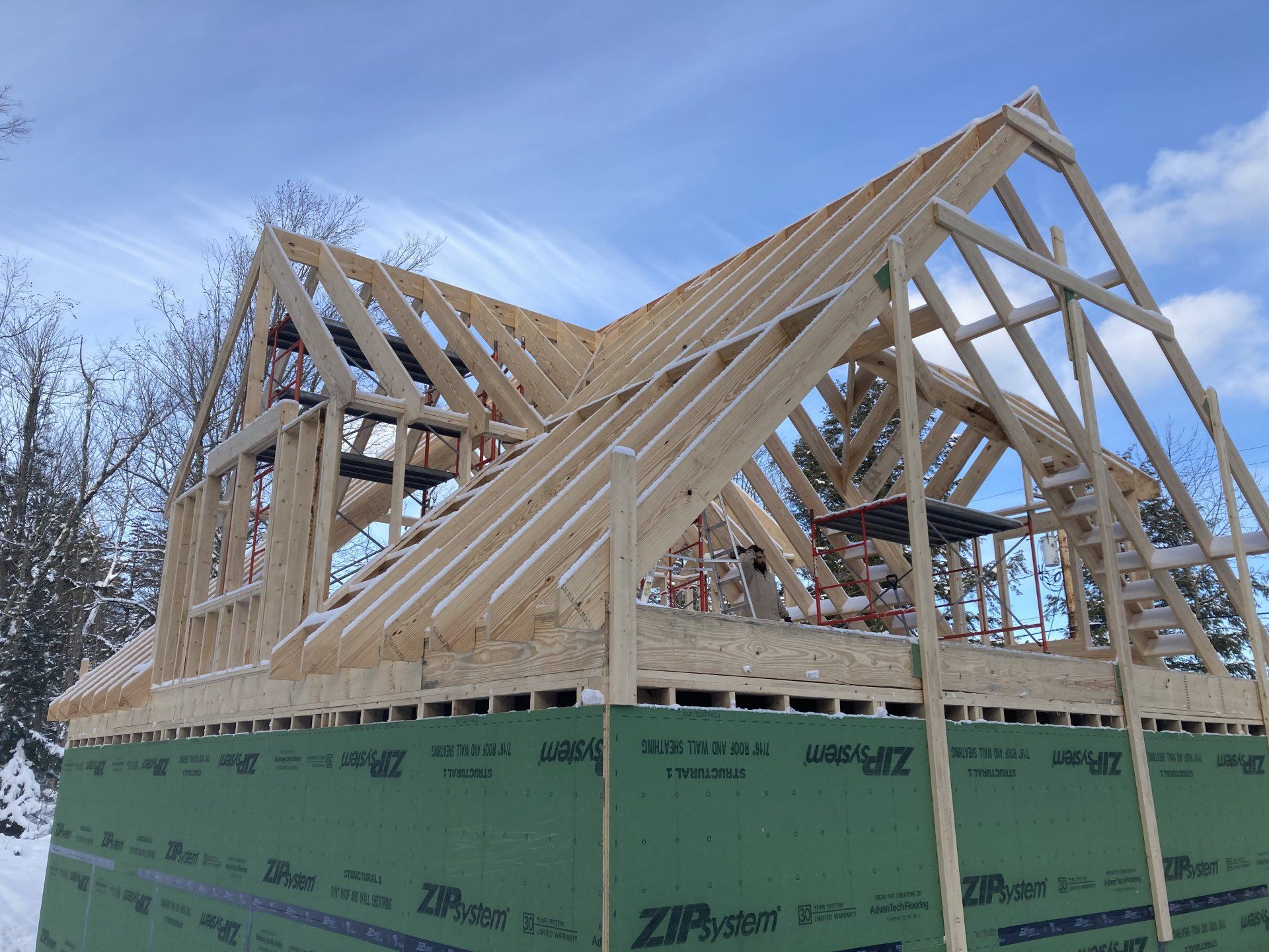 The roof of a house is being built in the snow