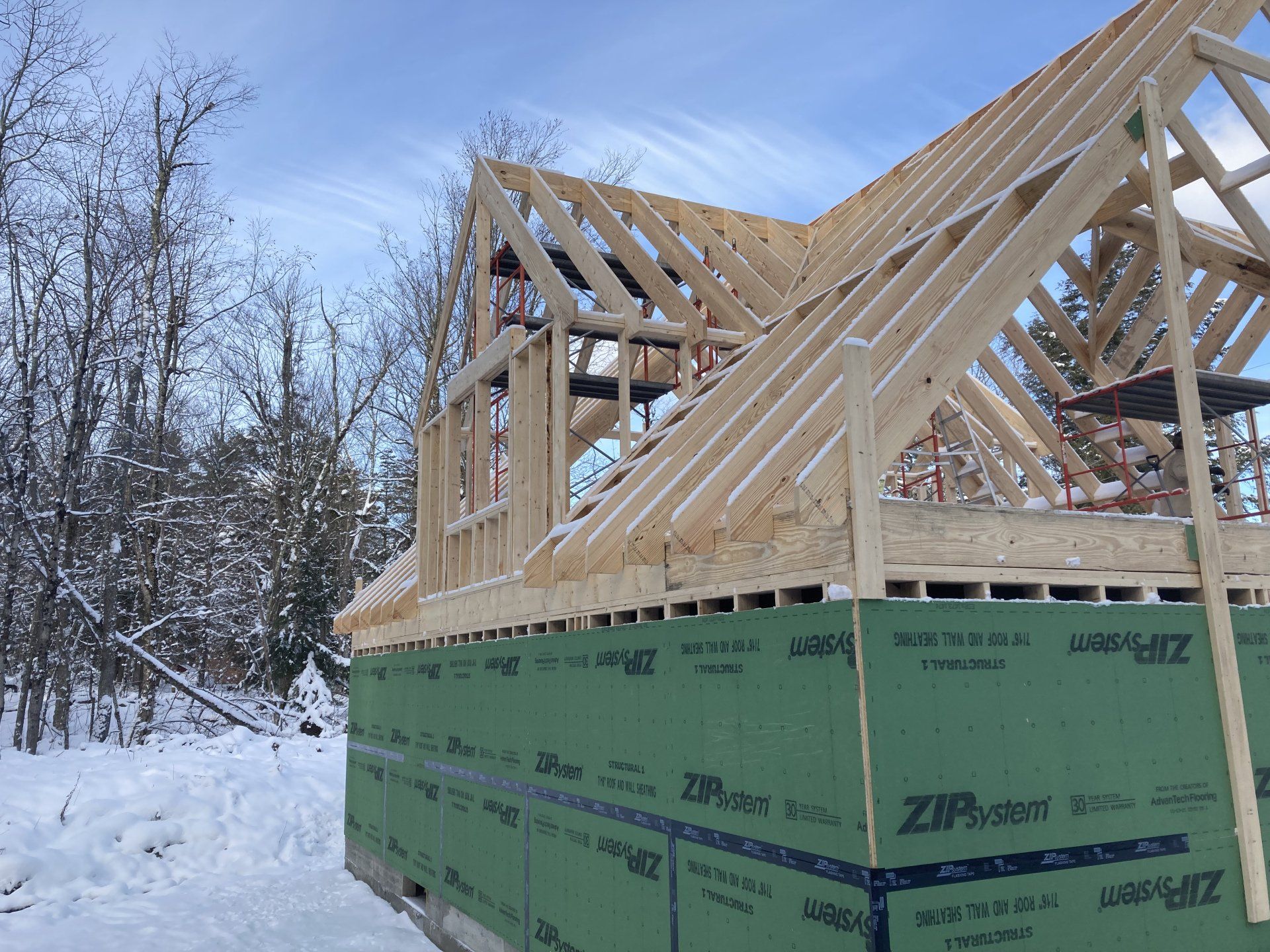 A wooden house is being built in the snow.