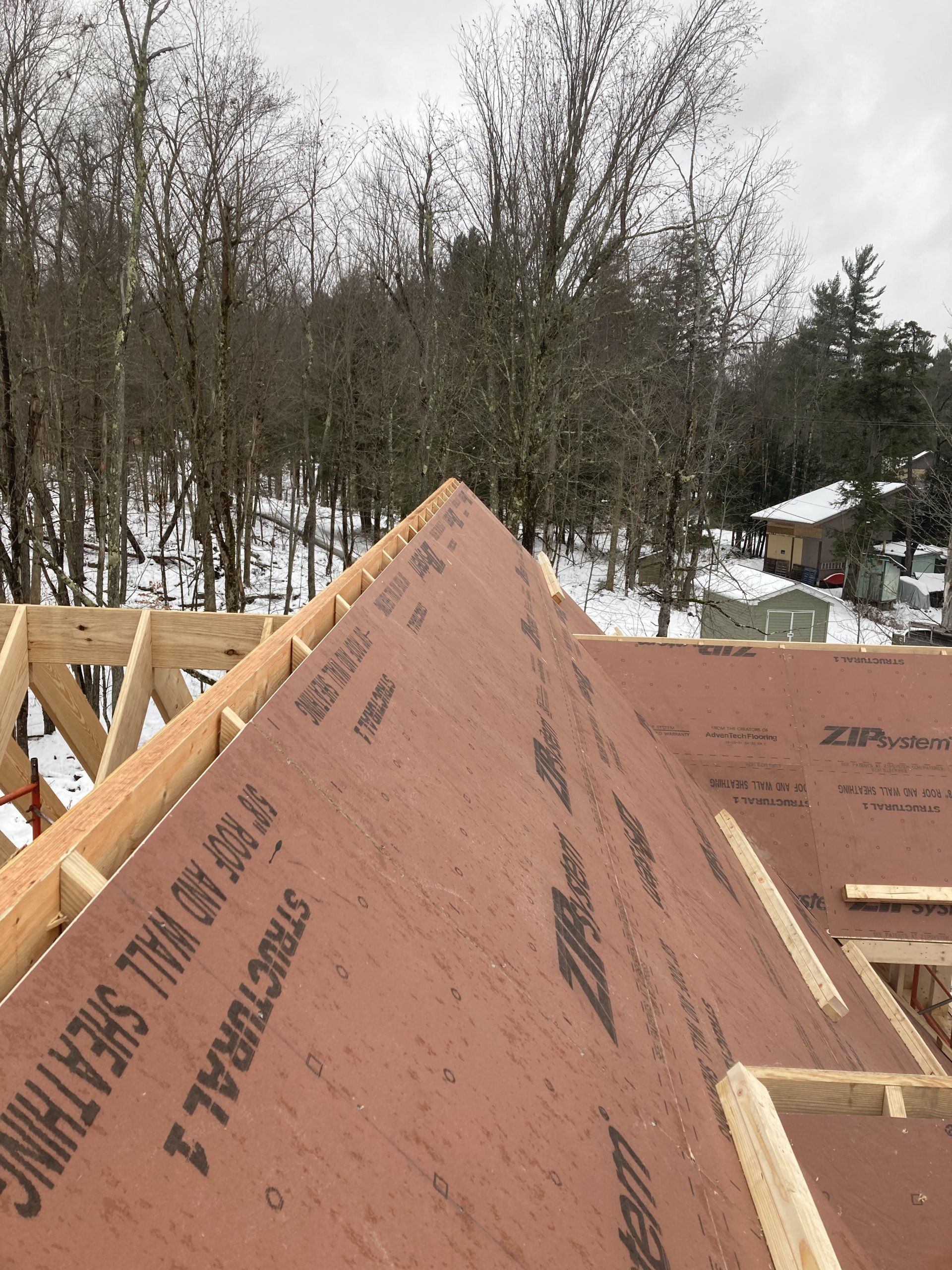 A roof is being built with a piece of plywood on it.