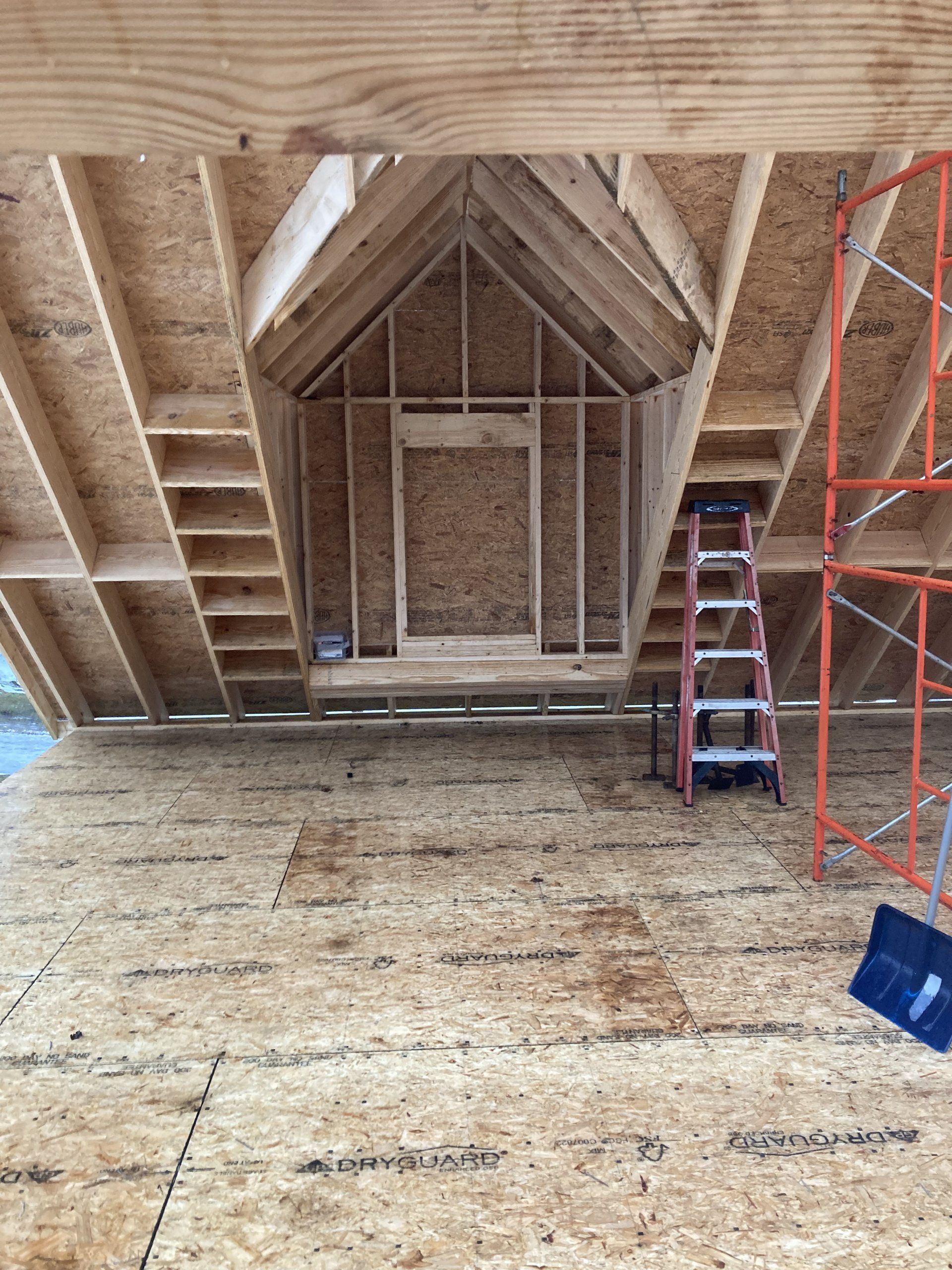 A ladder is sitting in the attic of a house under construction.