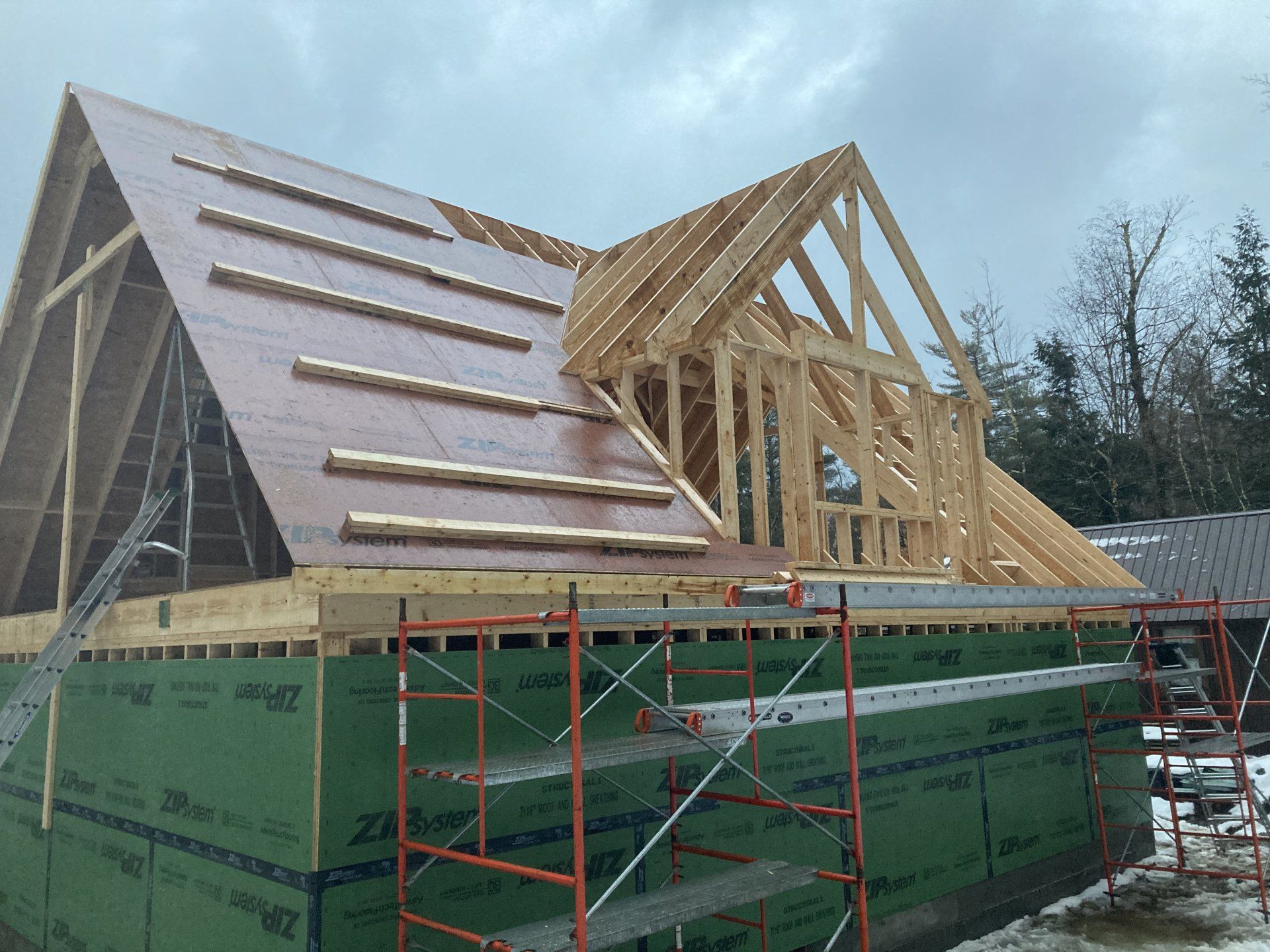 A house is being built with a wooden roof and scaffolding.