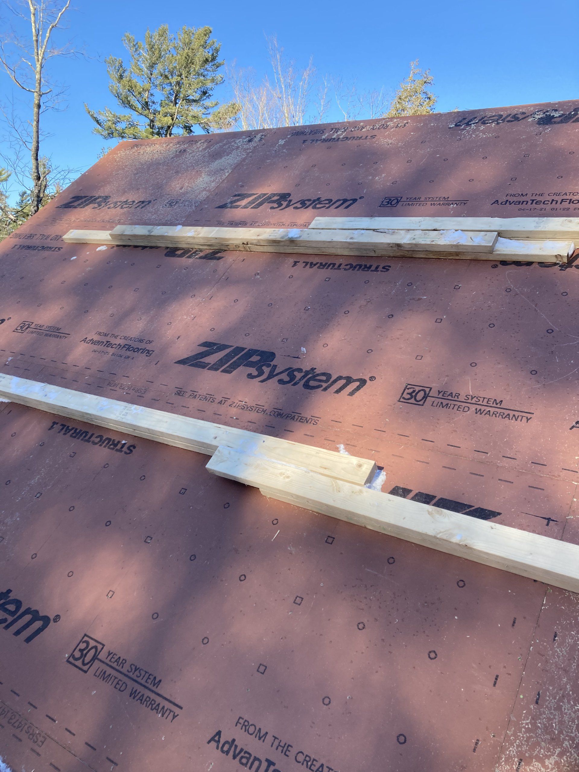 A roof with a lot of shingles on it and a blue sky in the background.