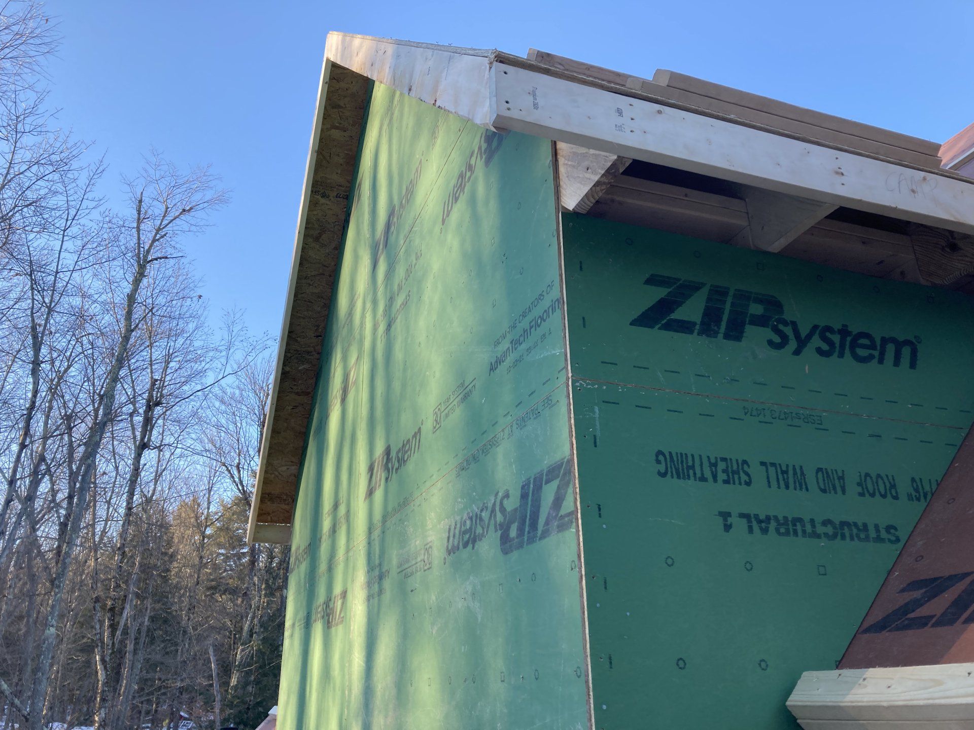 The side of a house is covered in green zipsystem.