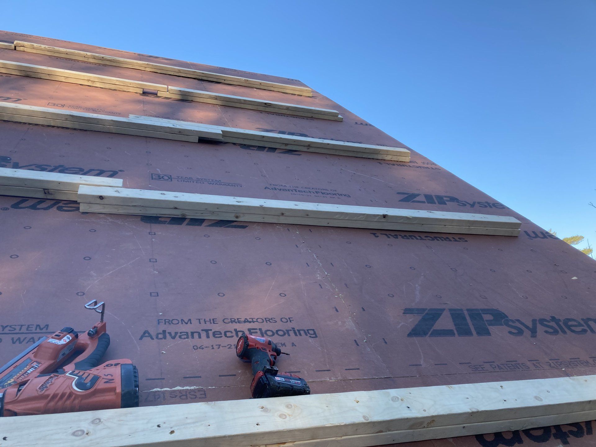A drill is sitting on top of a roof that is being built.