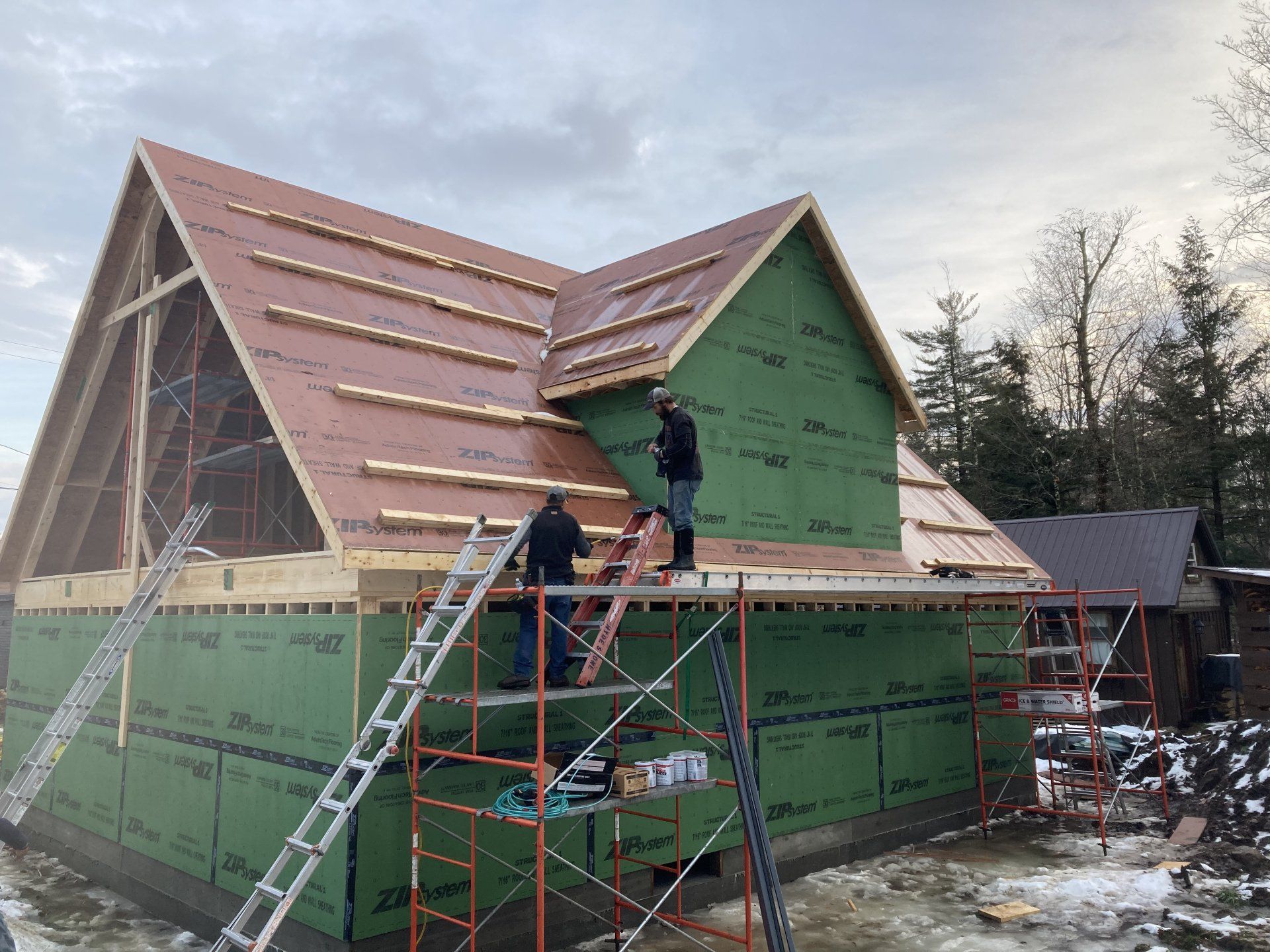 A group of people are working on the roof of a house.