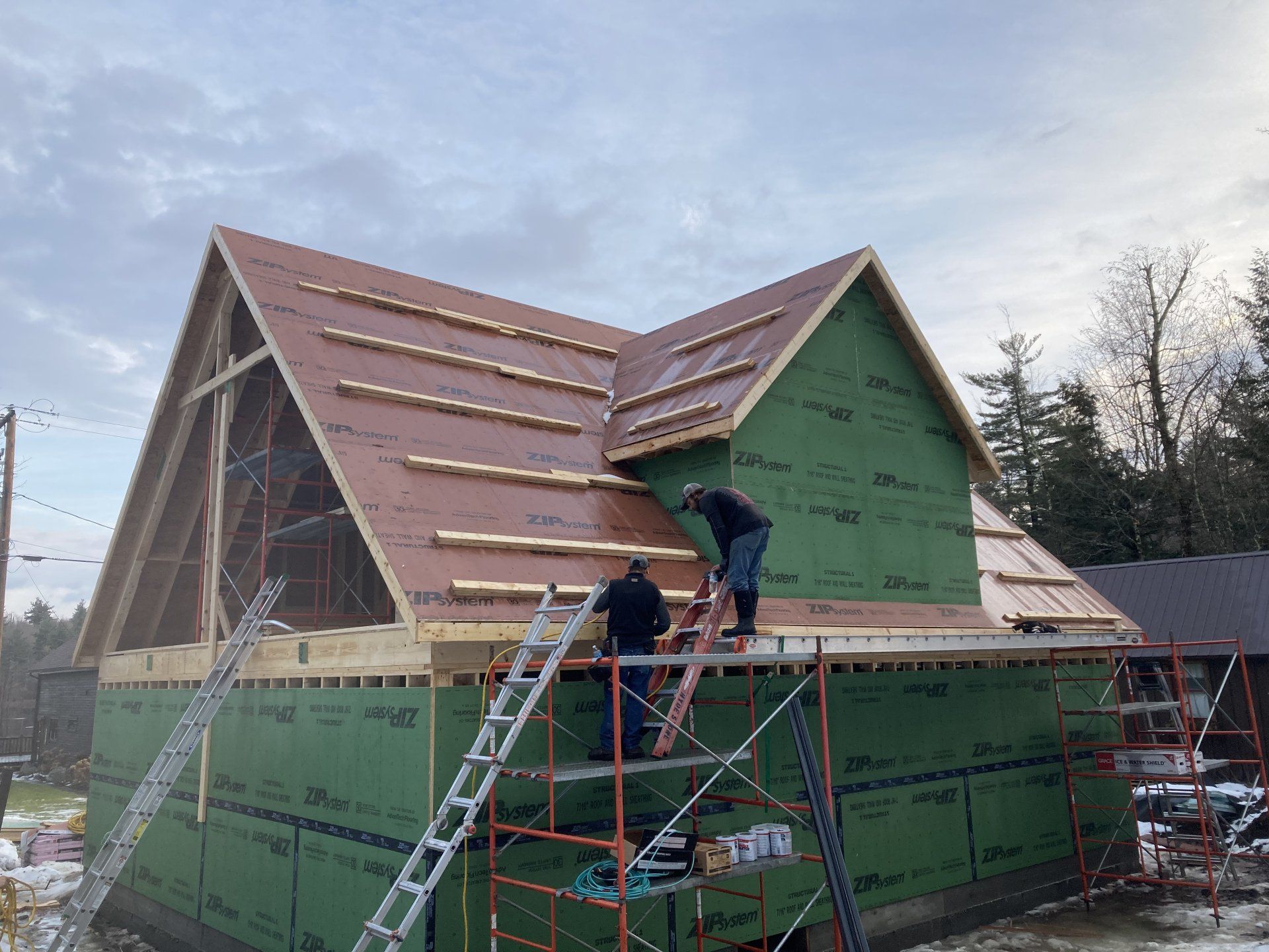 Two men are working on the roof of a house.