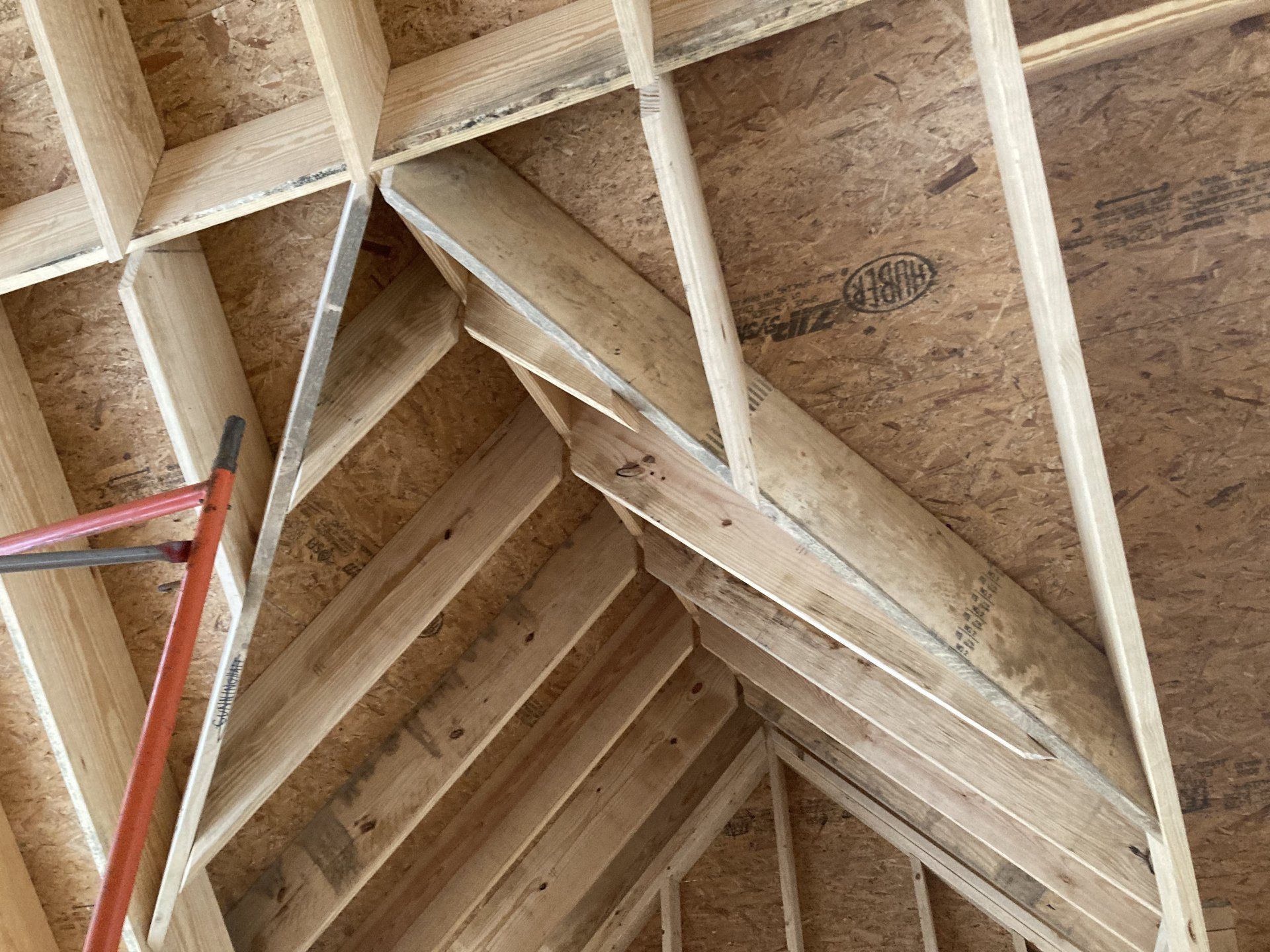A ladder is hanging from the ceiling of a building under construction.
