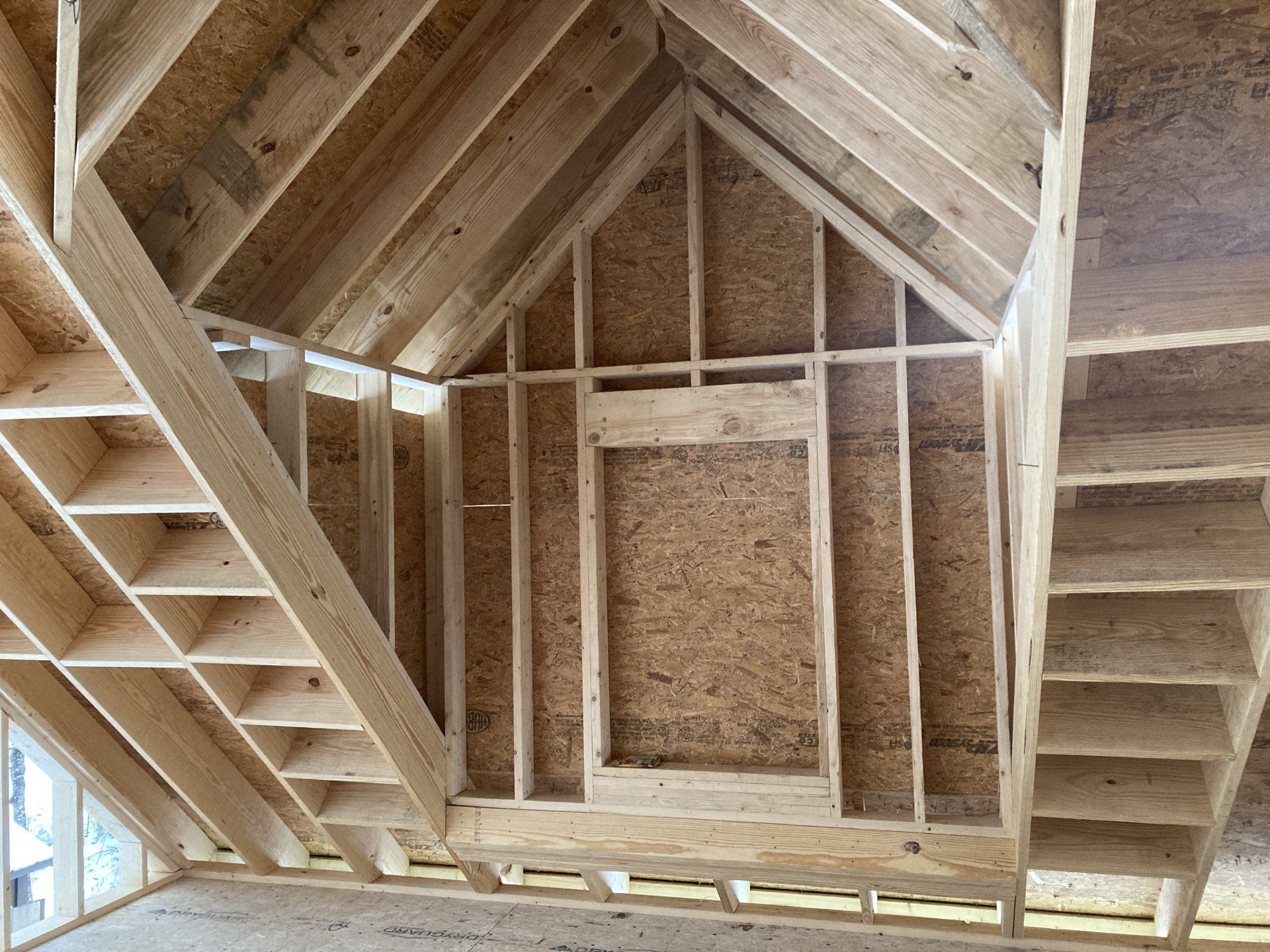 A wooden structure under construction with stairs and shelves