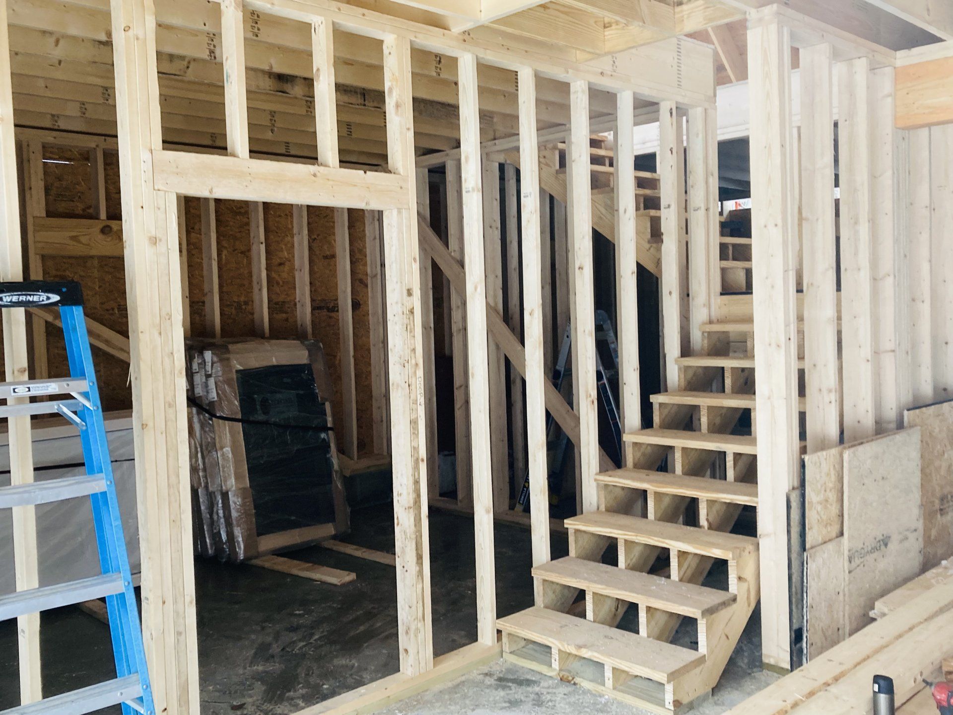 A house is being built with stairs and a ladder.