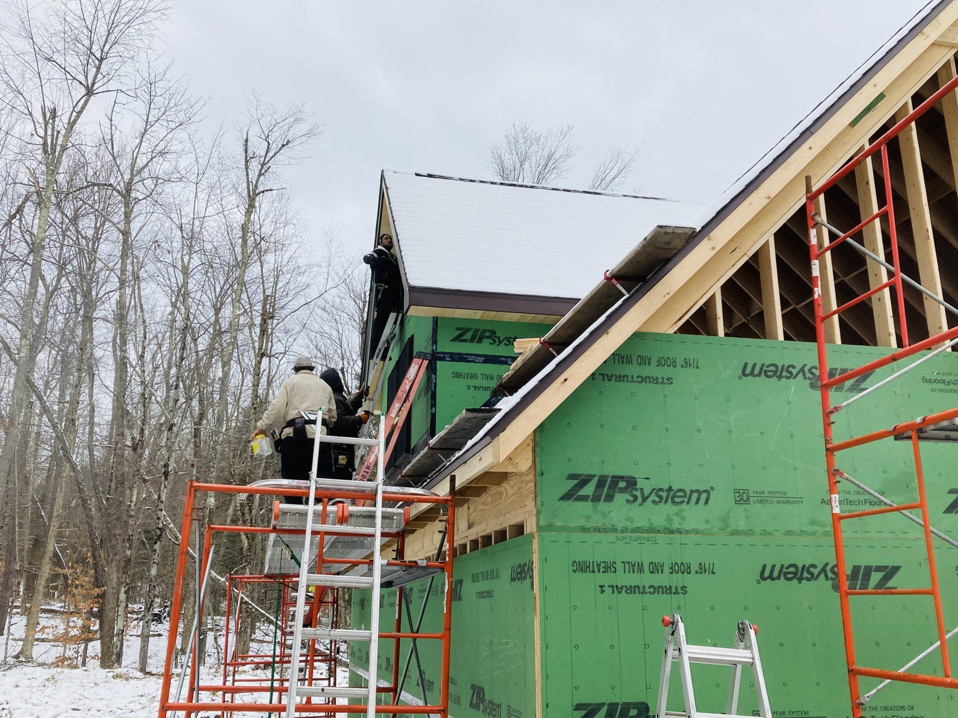 A man is working on the roof of a house that is being built