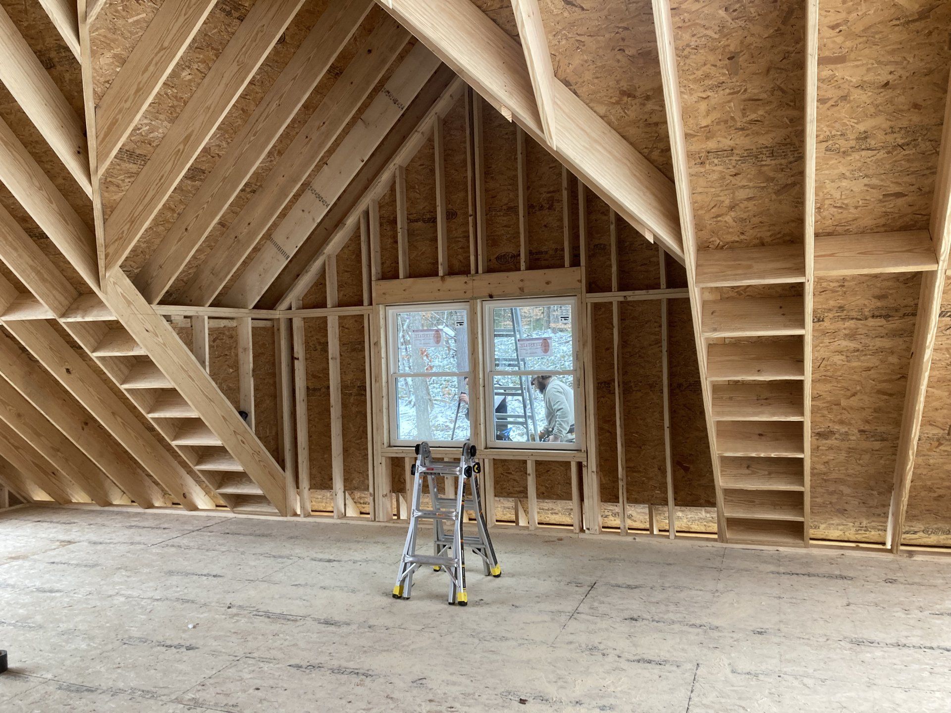 A ladder is sitting in the attic of a house under construction