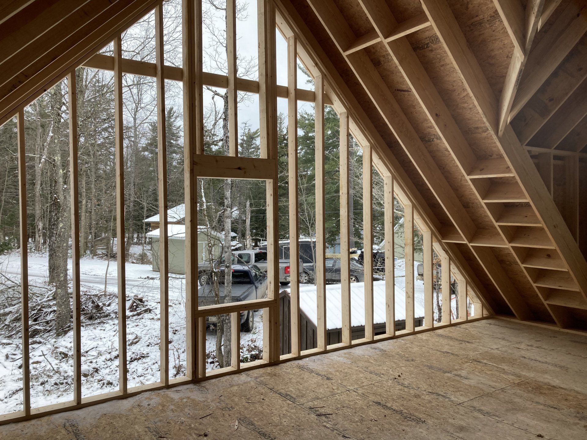 A room with a lot of windows and a view of a snowy forest