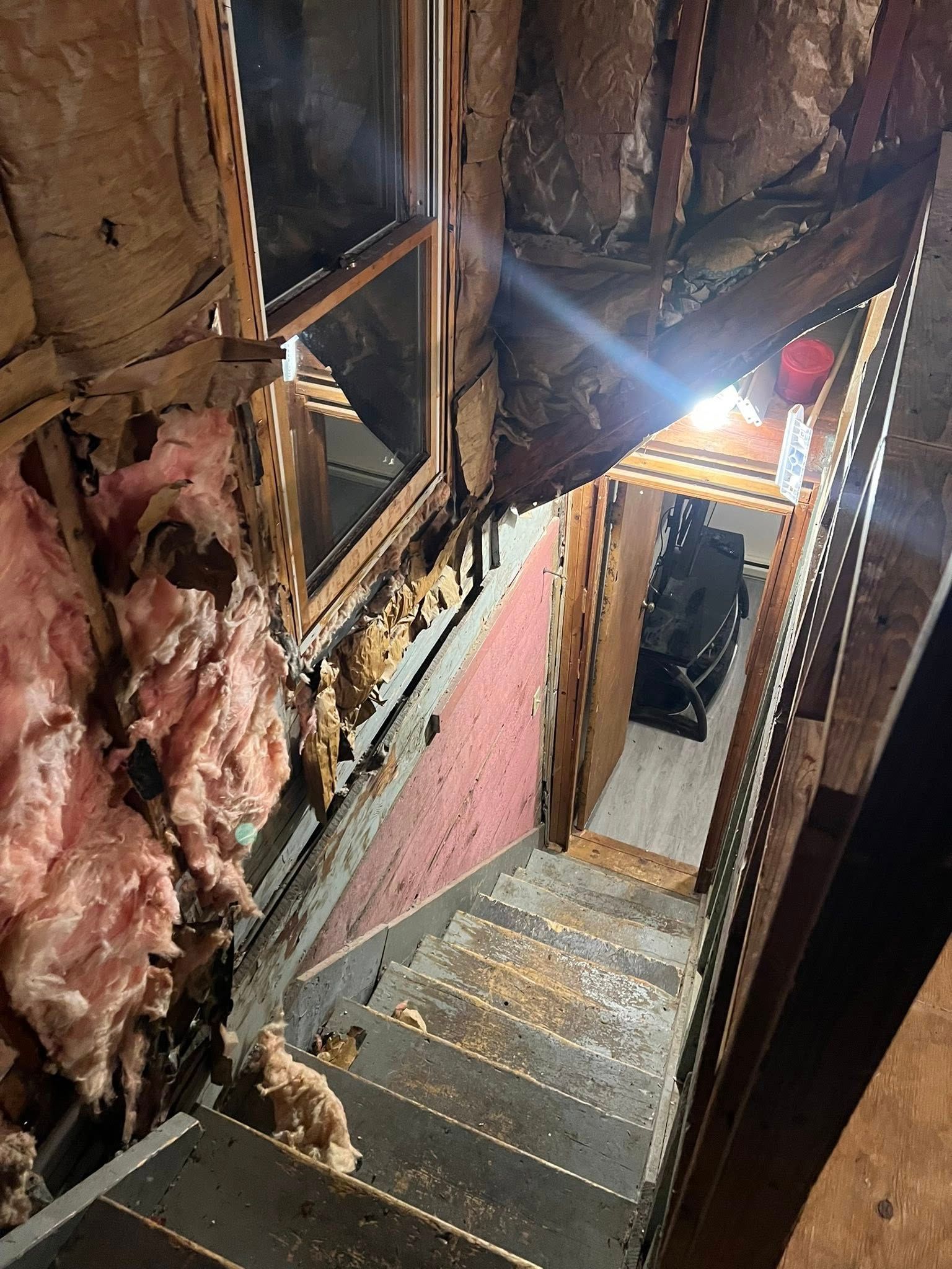 An empty room with hardwood floors and a white door.