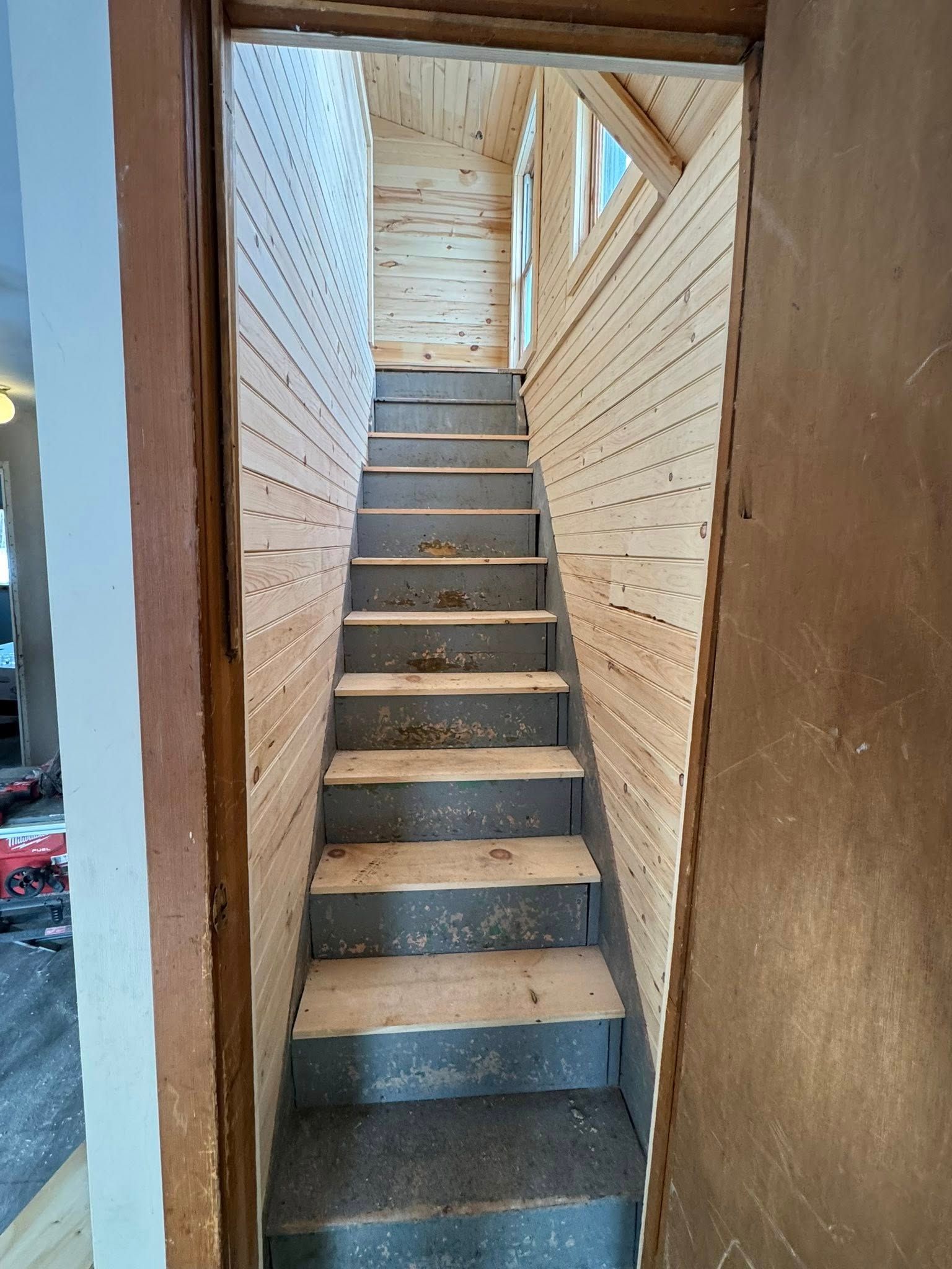 A room under construction with a bucket of paint on the floor.