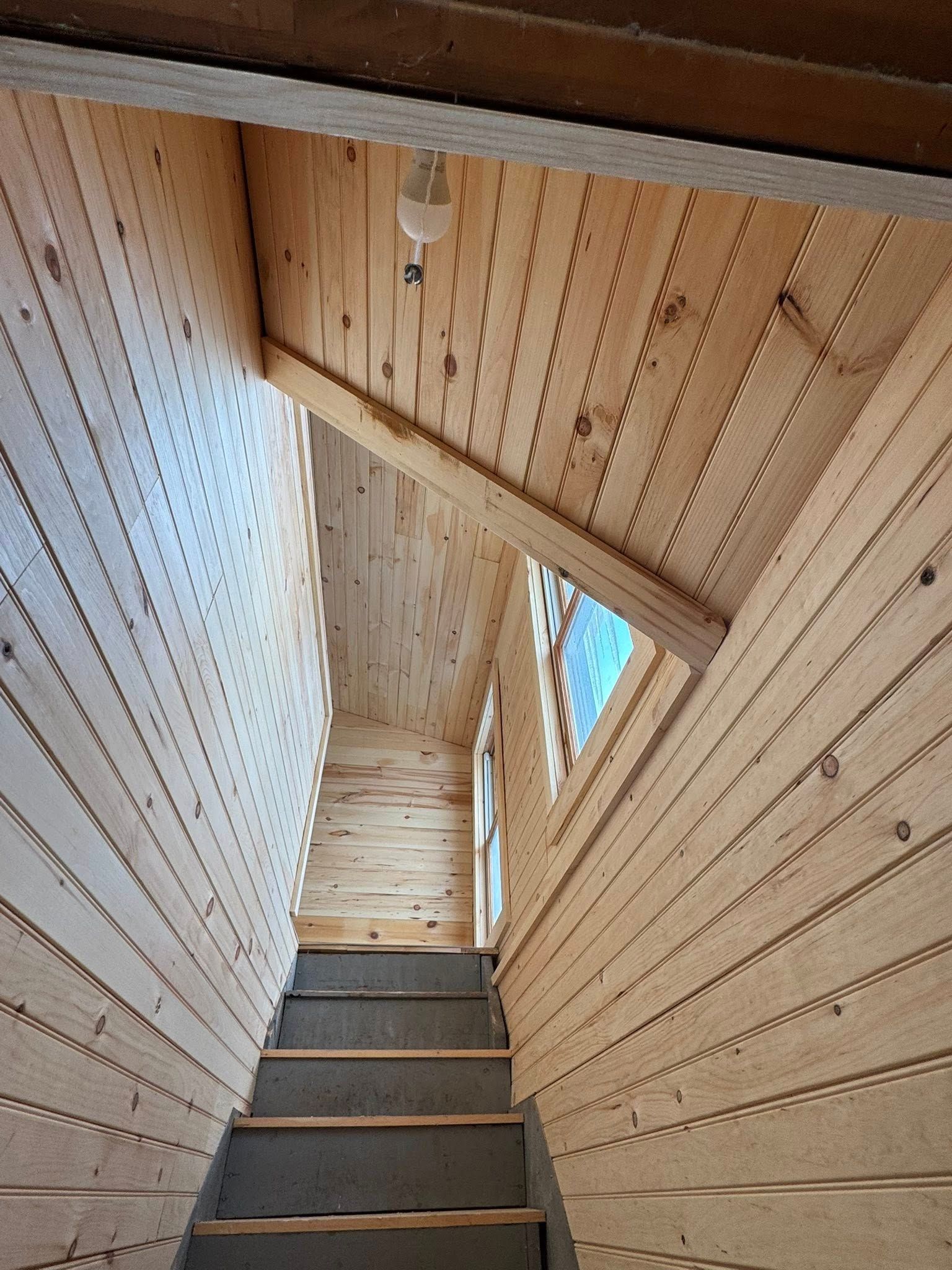 A wooden frame is sitting on top of a concrete floor next to a blue tarp.