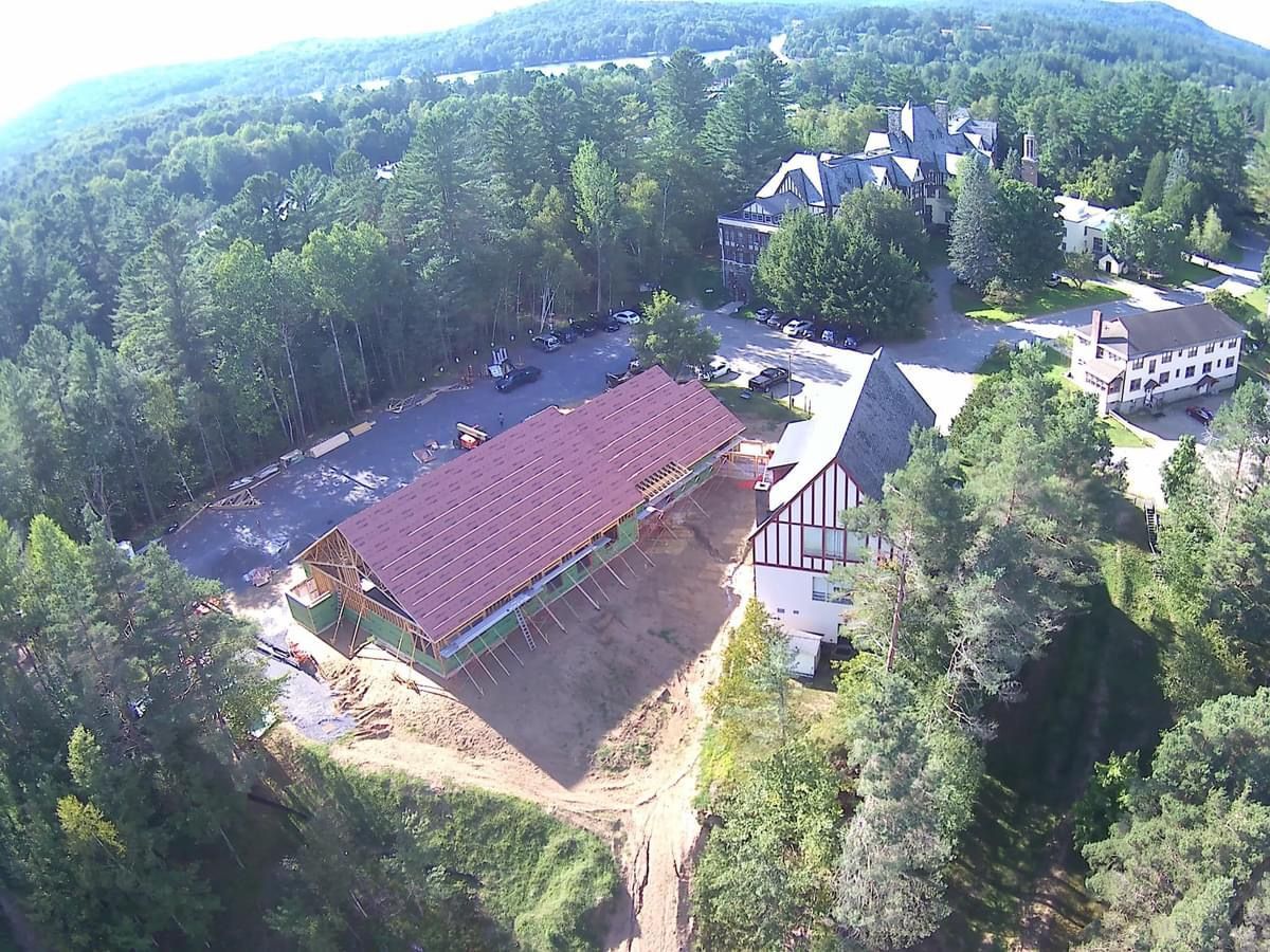 An aerial view of a building in the middle of a forest.