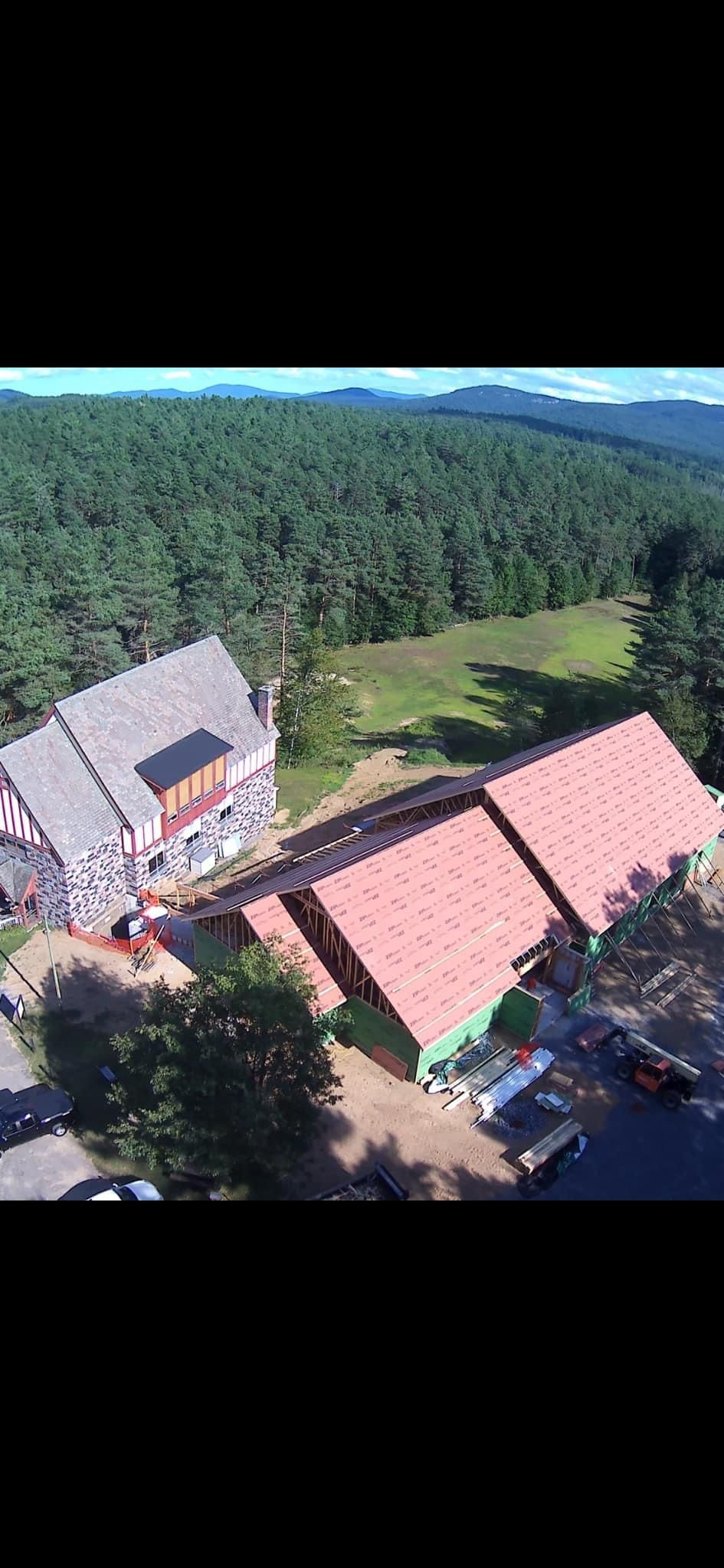 An aerial view of a large building in the middle of a forest.
