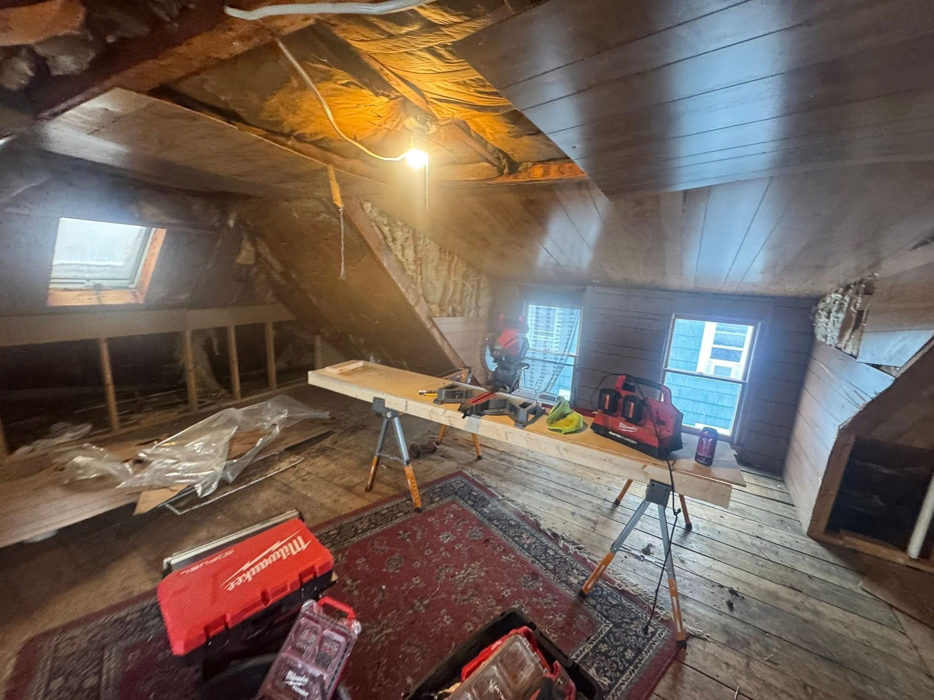 A wooden house is sitting next to a pile of gravel.