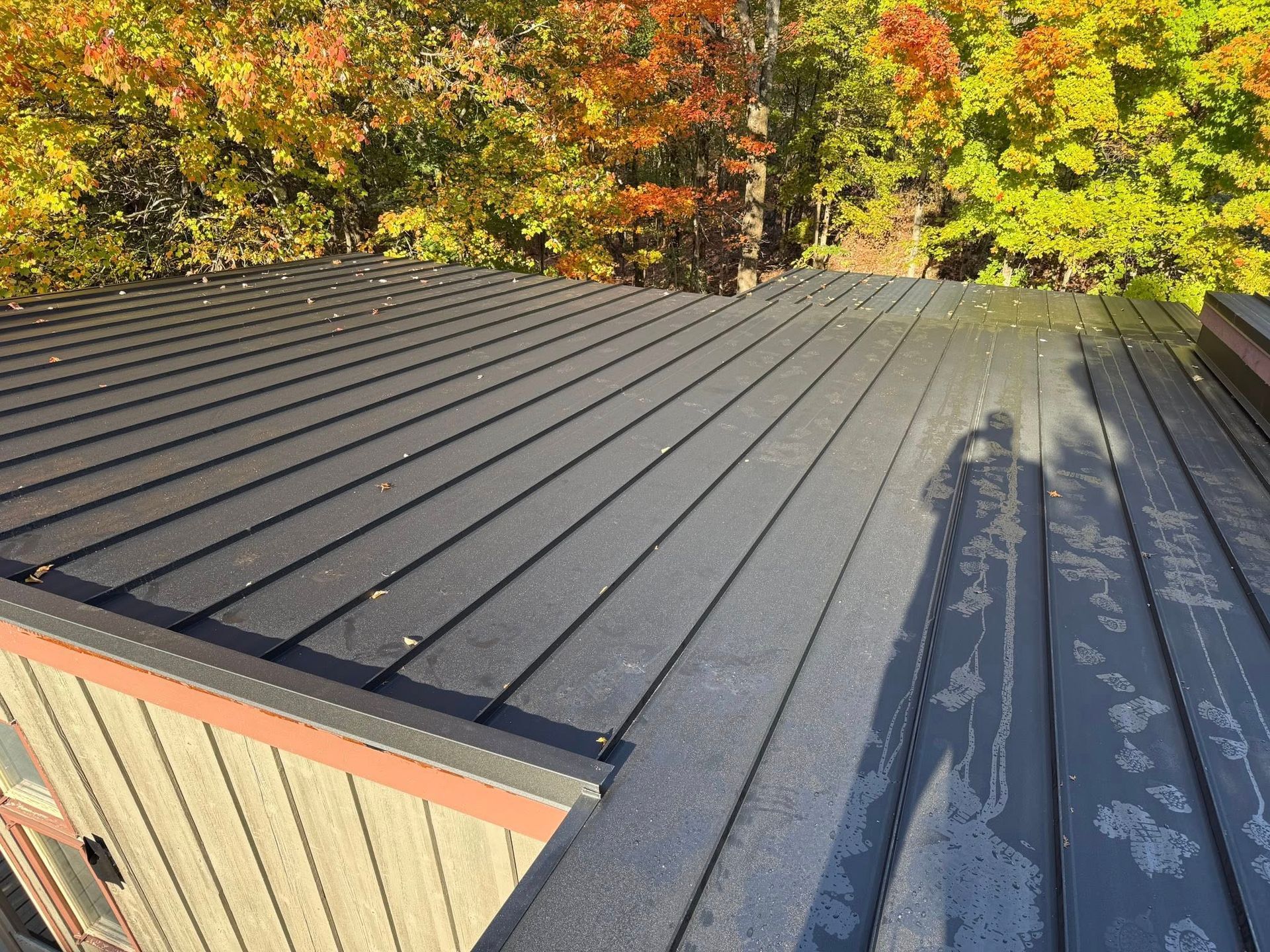 A brick house with a blue roof is being remodeled.
