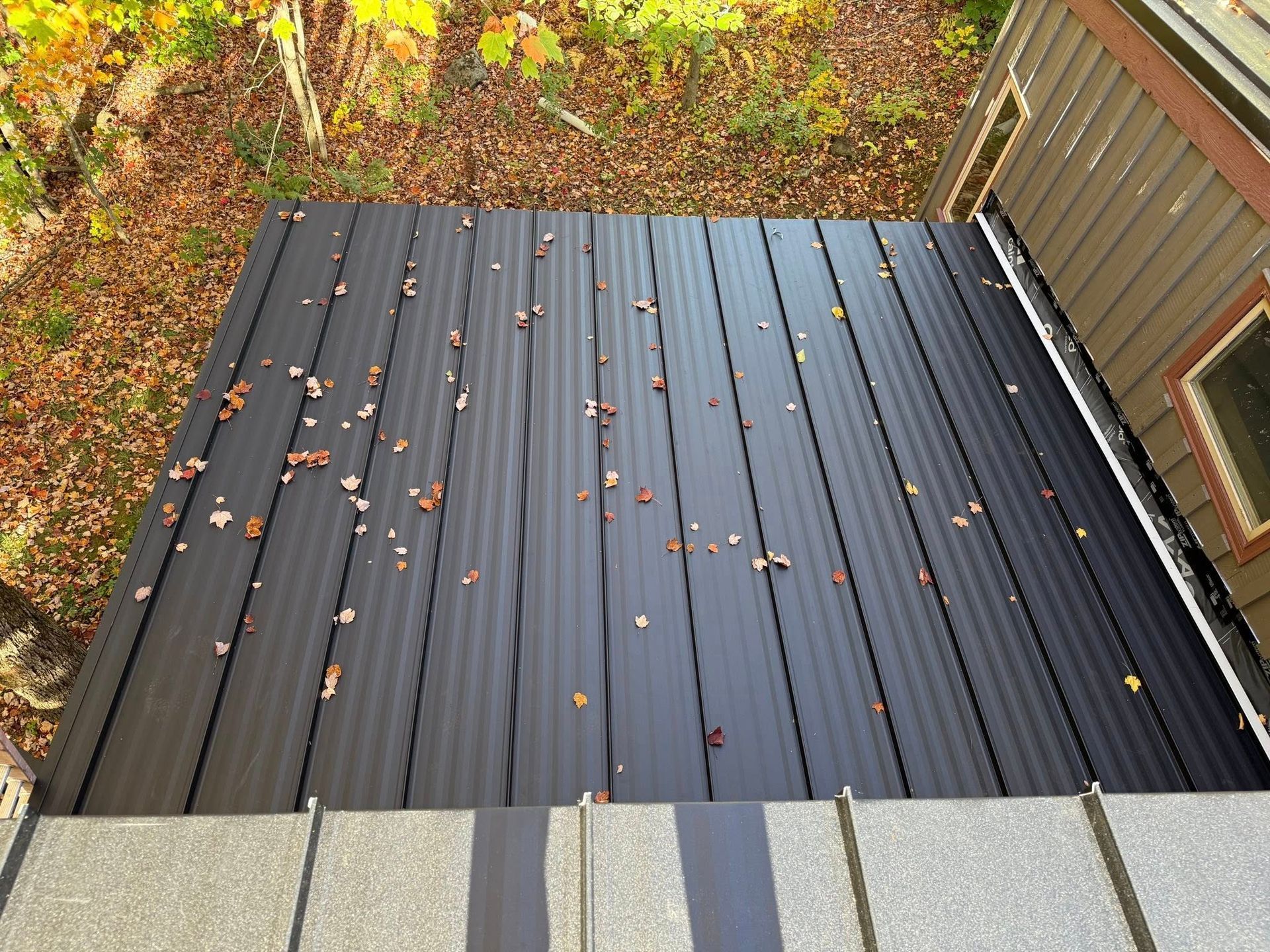A white house with a black roof and a porch