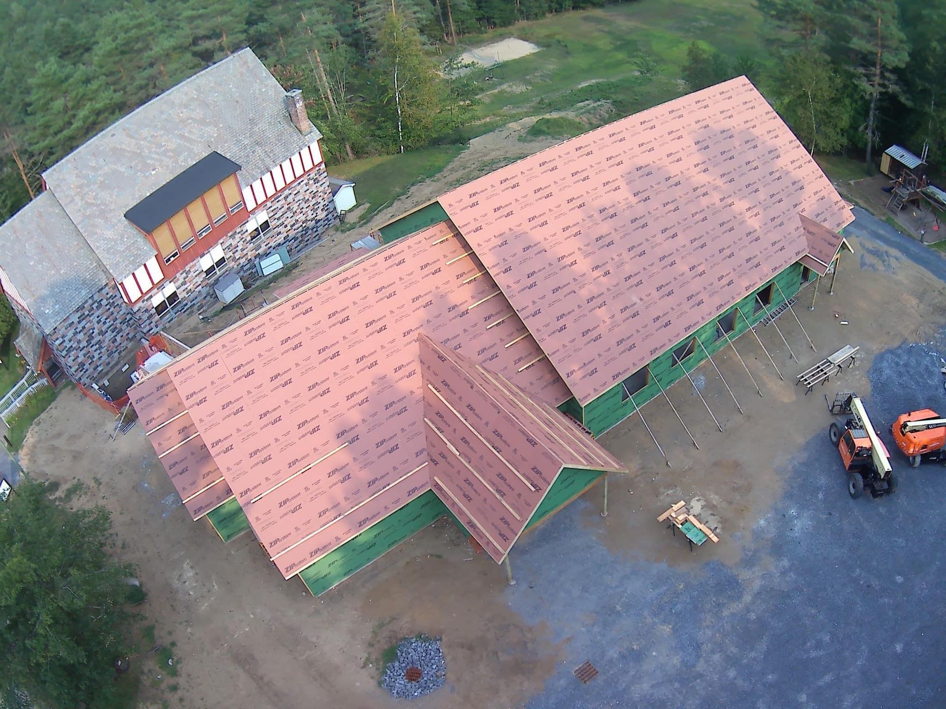 An aerial view of a building under construction with a red roof