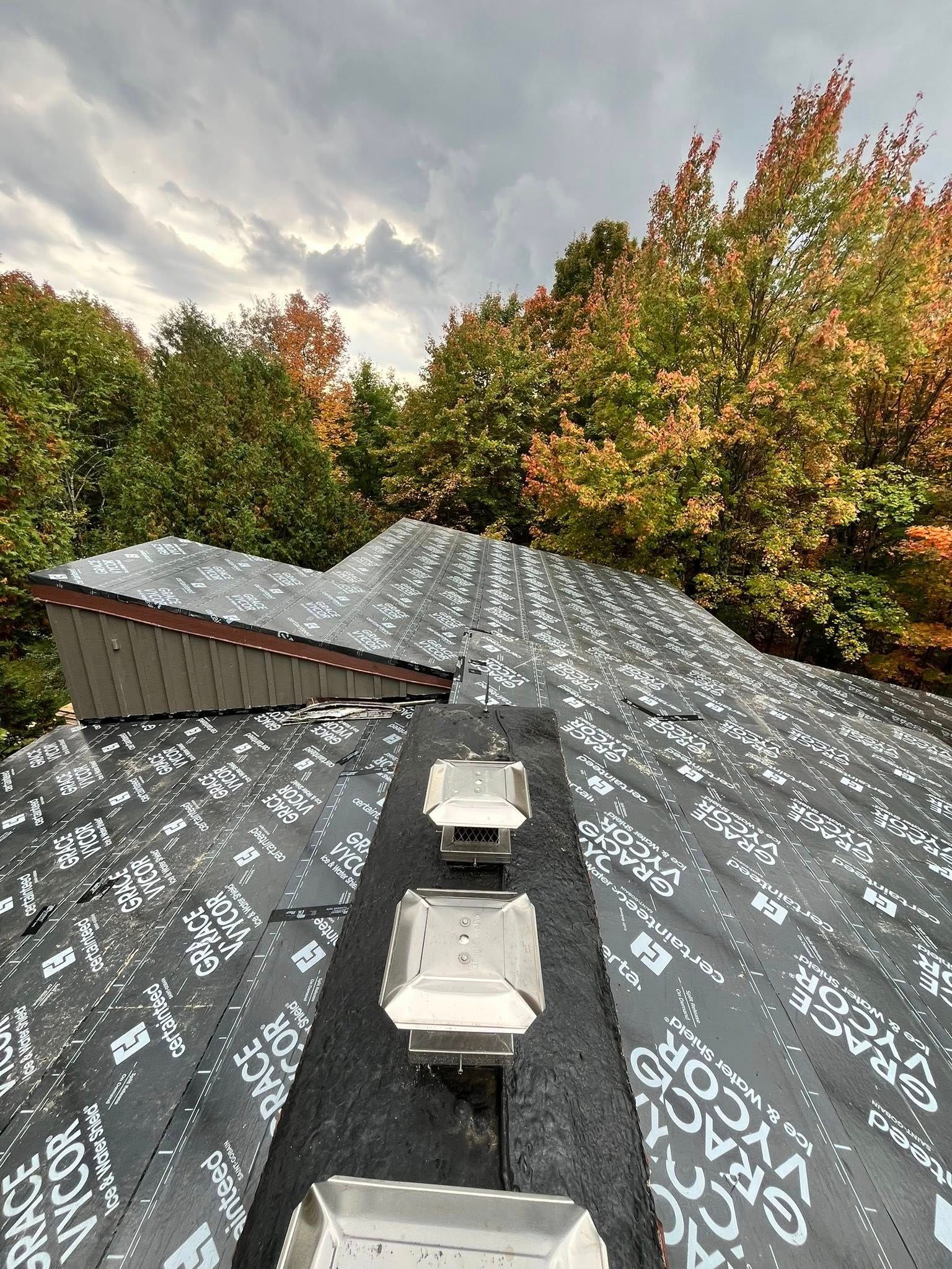 A group of men are working on the roof of a building.
