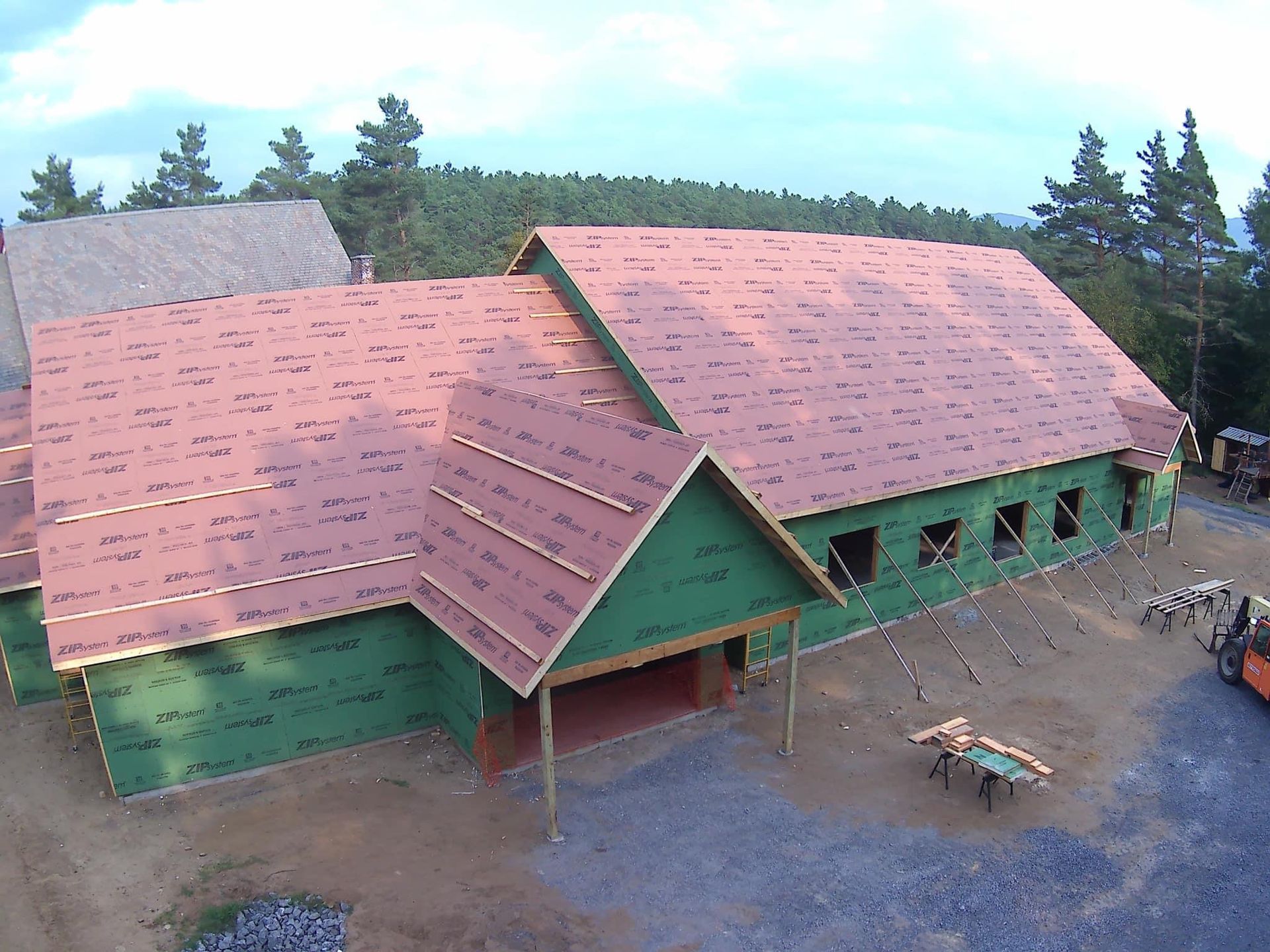 An aerial view of a house under construction with a red roof