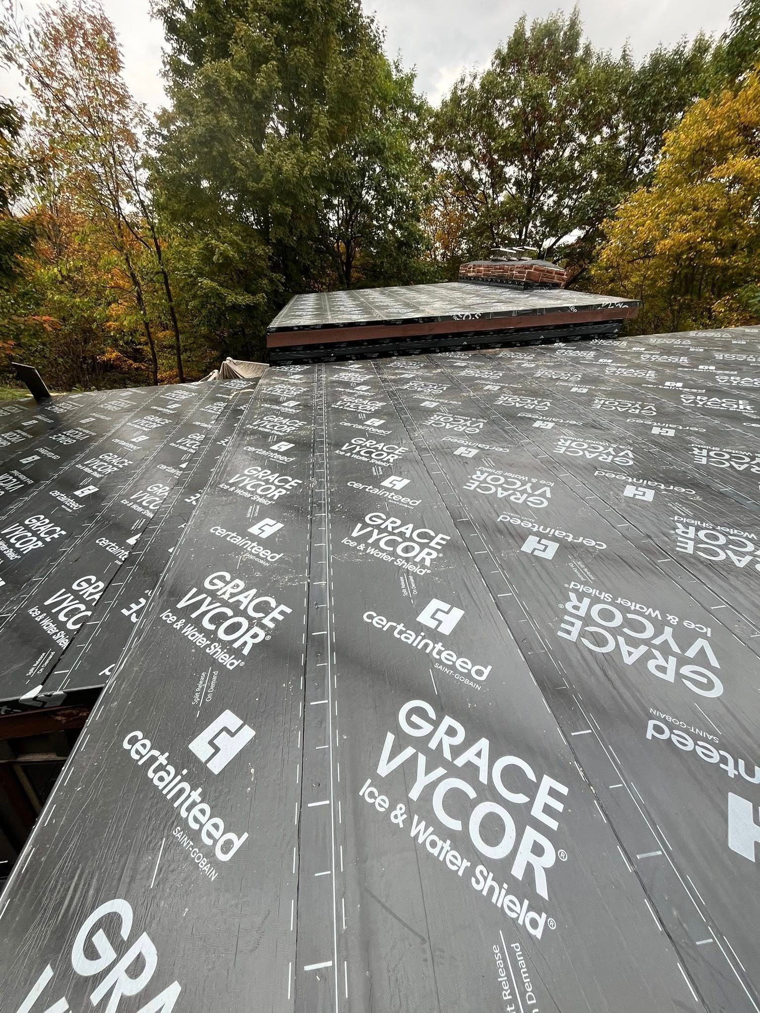 A brick building is being remodeled with scaffolding and blue tarps.
