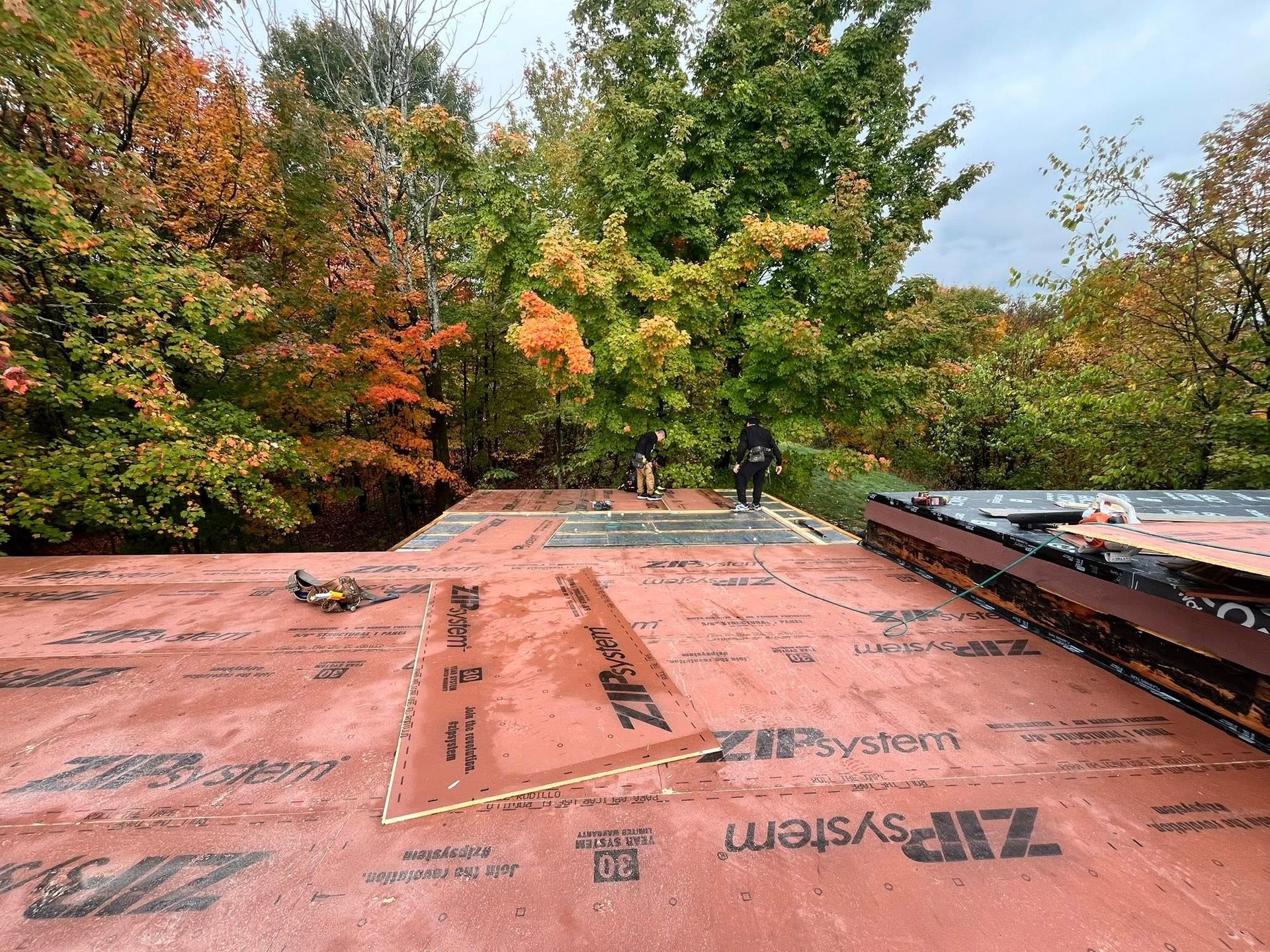 A group of people are working on the roof of a house.