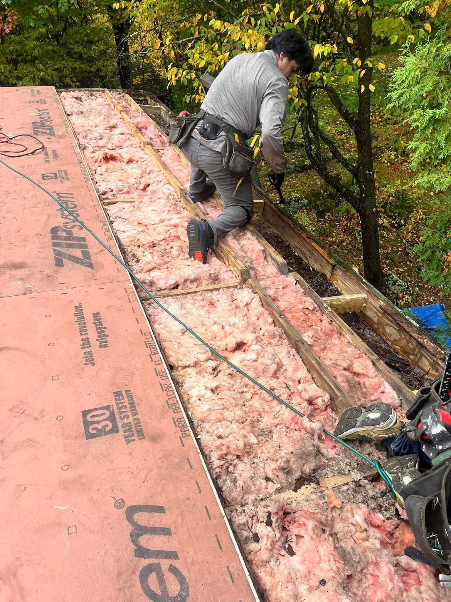 A car is parked in front of a house with a trailer attached to it.