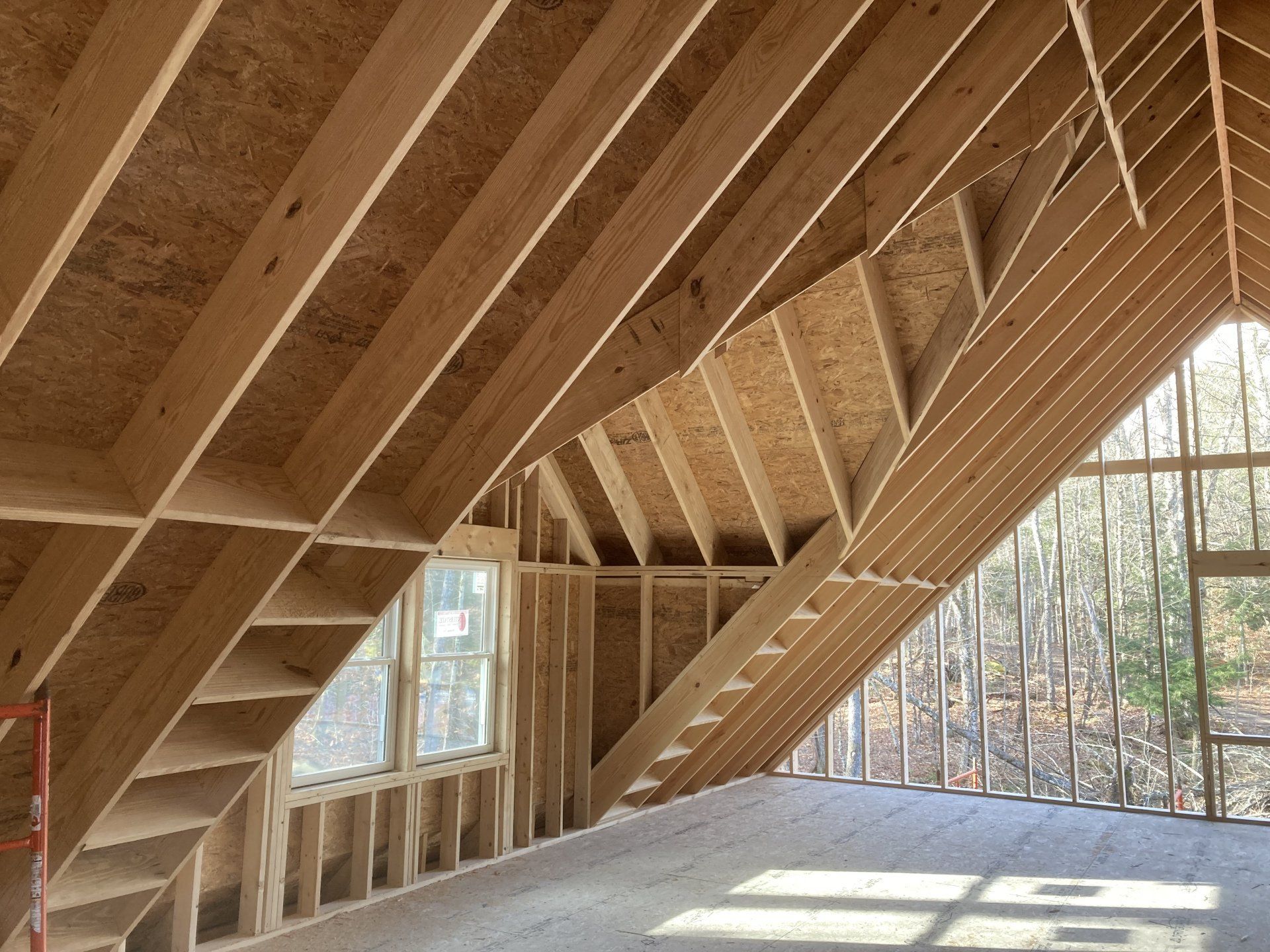 A room with a wooden ceiling and stairs in a house under construction.
