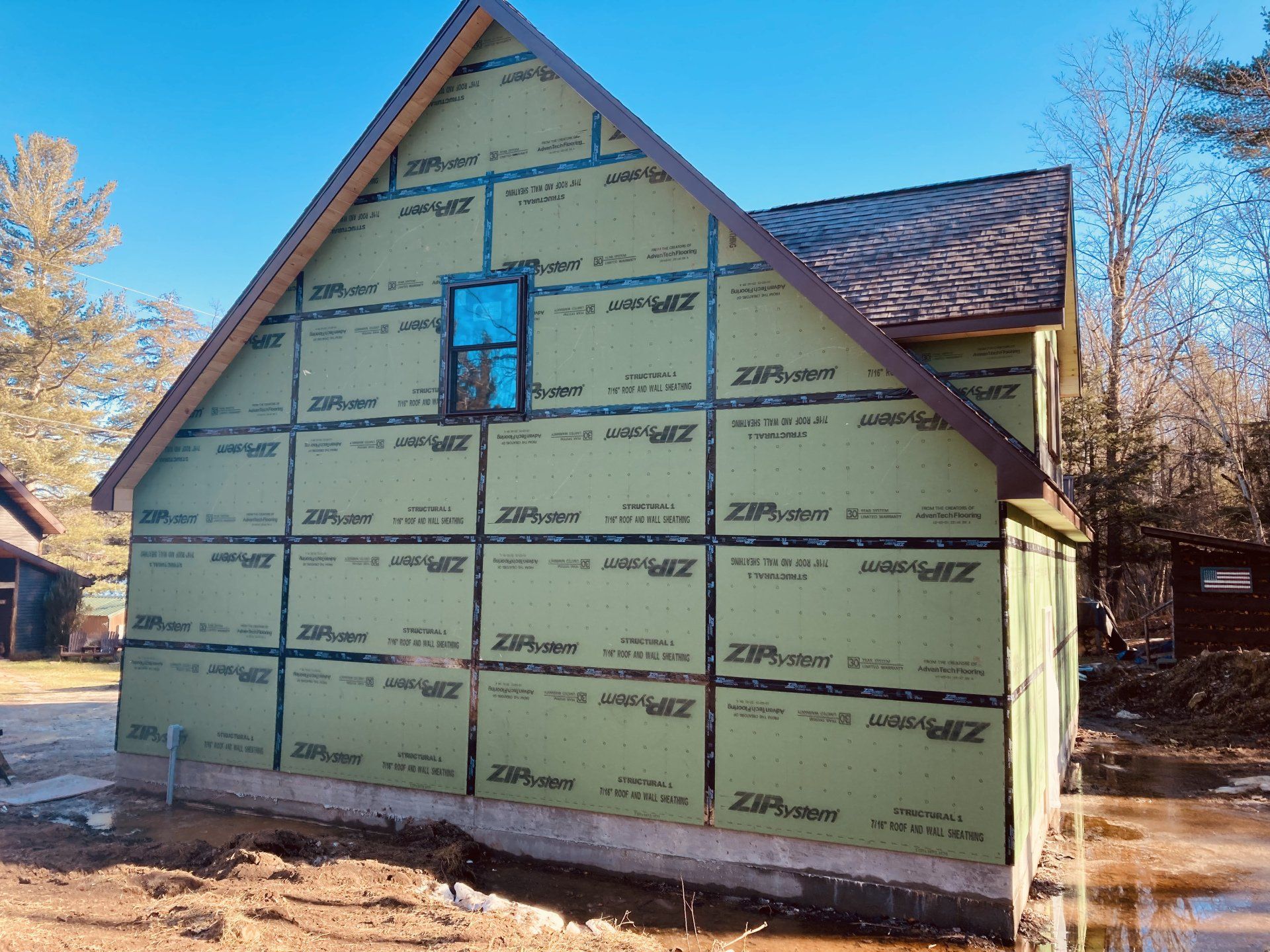 A house is being built with a lot of green siding
