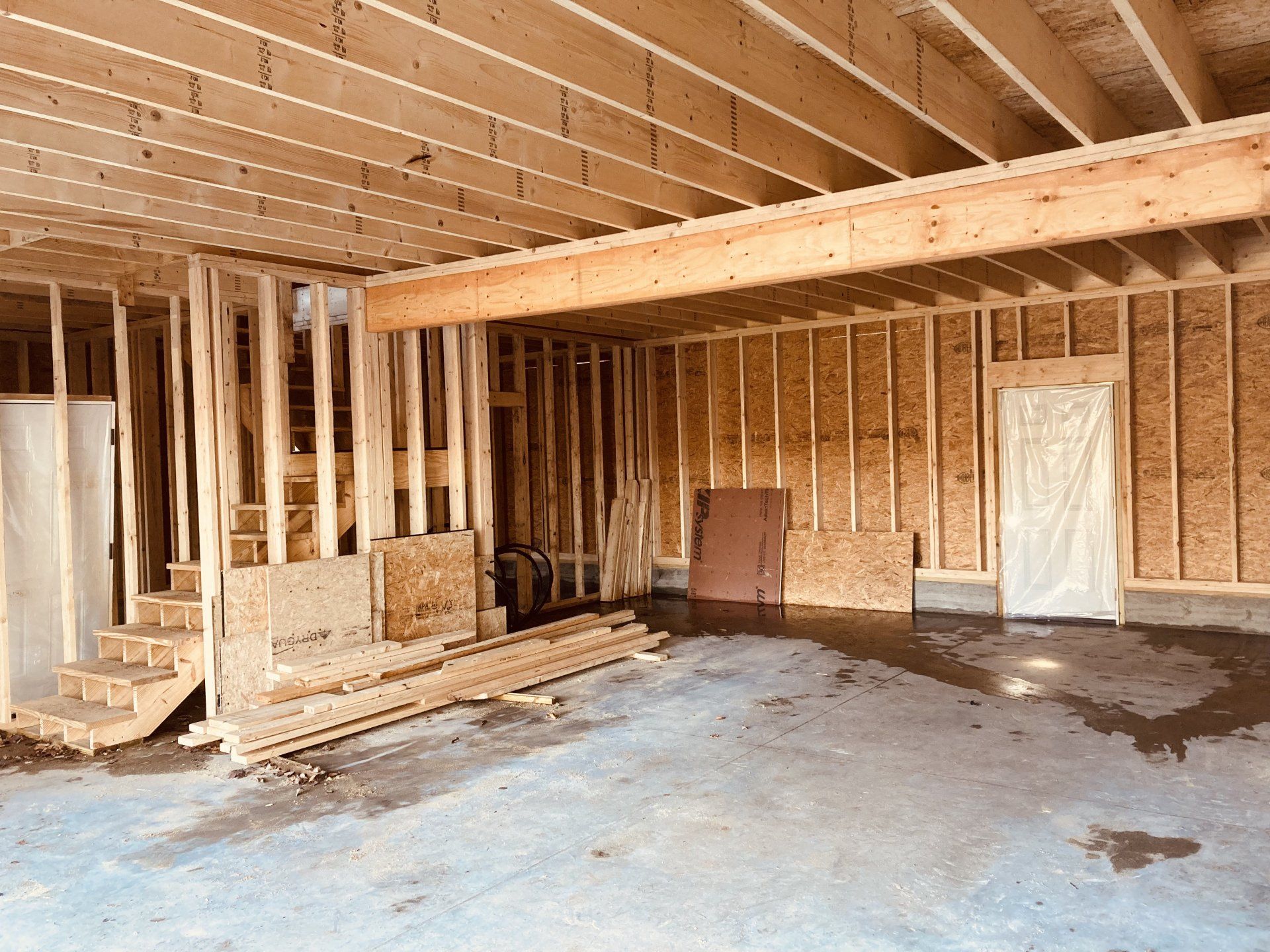A garage under construction with wooden beams and stairs.